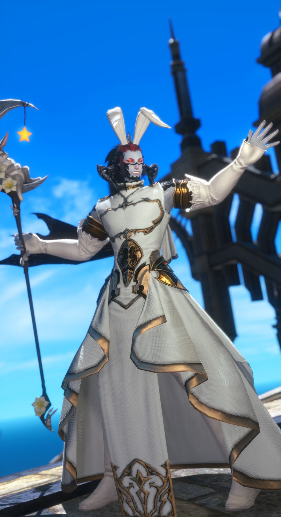 Male Au Ra with a grin striking a pose while holding a staff depicting a bunny sleeping on the Moon. He is wearing a long, flowing pure white robe with gold trims, pure white long-sleeve gloves and thighboots and a small crown with floppy bunny ears