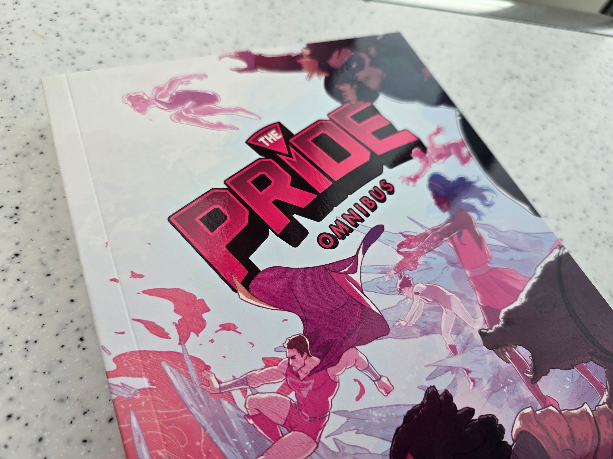 Joe Glass's The Pride in a full omnibus, collecting volumes and 2 as well as a collection of self-contained stories, The Pride Adventures! In The Pride, Fabman is sick of being seen as a jo the LGBTQ+ community being seen as inferior to heroes, he thinks it's about damn time he did something about it. Bringing together some of the world's greatest LGBTQ+ superheroes, the Pride is born to protect the world and fight prejudice, misrepresentation, and injustice-not to mention a pesky supervillain or two. The Pride Adventures brings a whole host of extra self-contained stories and adventures starring the heroes of the Pride! See the team members face down crazed shooters, invasions, and even a sixty-foot-tall drag queen! Featuring a slew of incredible artistic talent, plus stories from writers Mike Garley, Sina Grace, and PJ Montgomery too! Follow the LGBTQ+ heroes into whole new stories and meet even more characters in the world of The Pride!