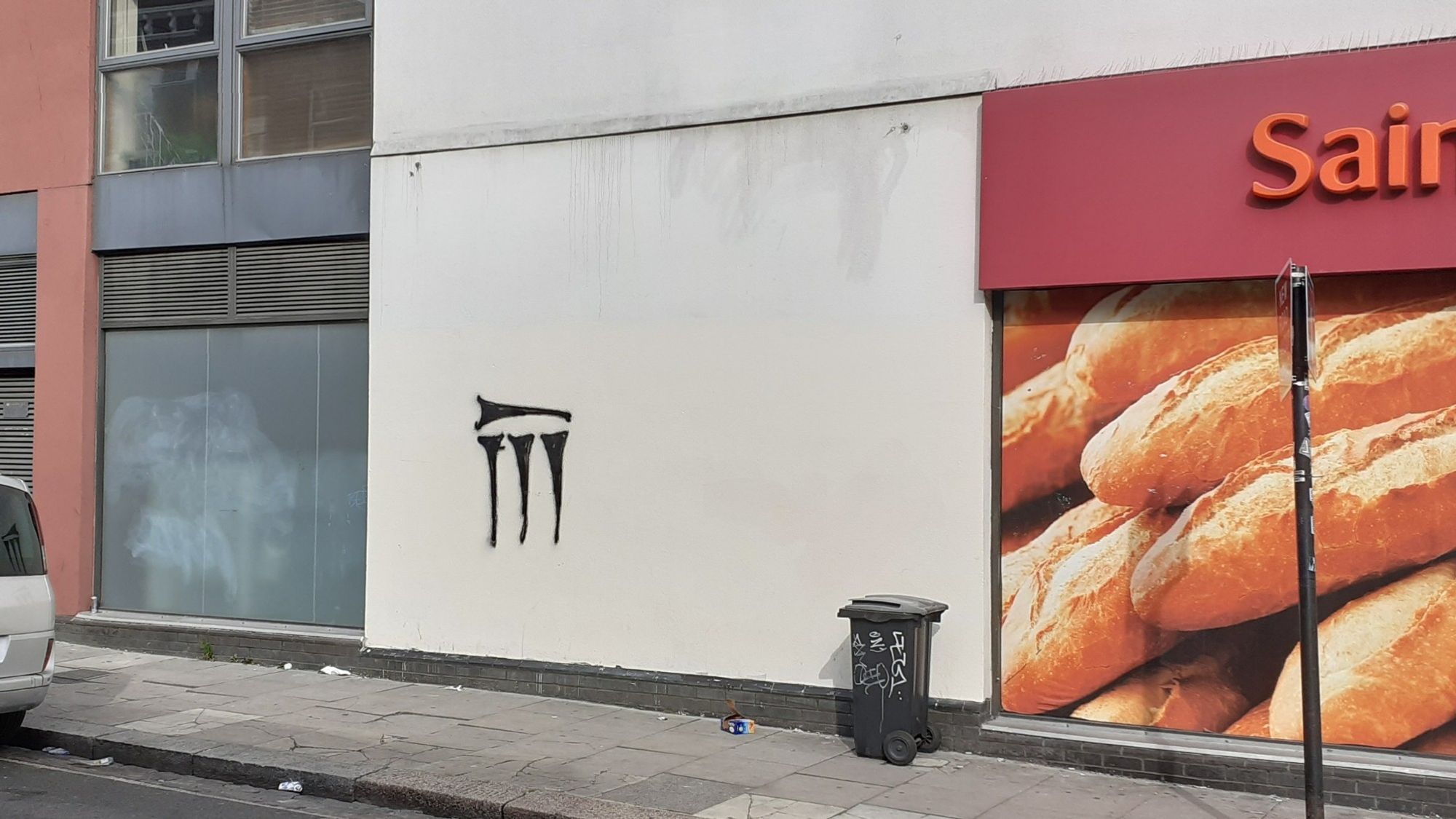 Graffiti on a wall near a Sainsbury's that looks a bit like cuneiform 