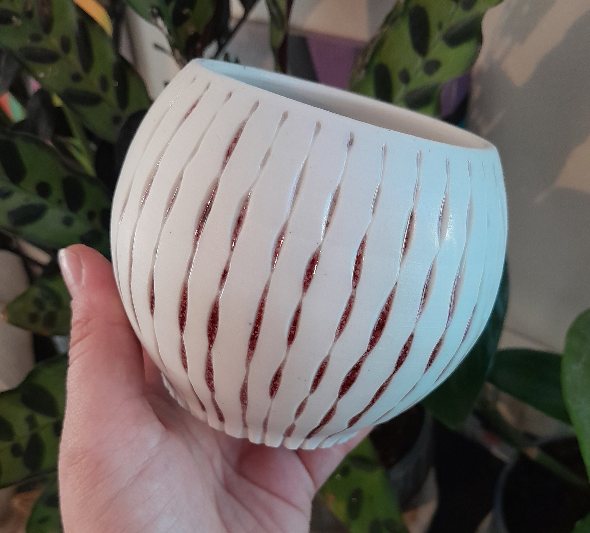 White translucent porcelain luminary carved with a blood red copper glaze in the grooves