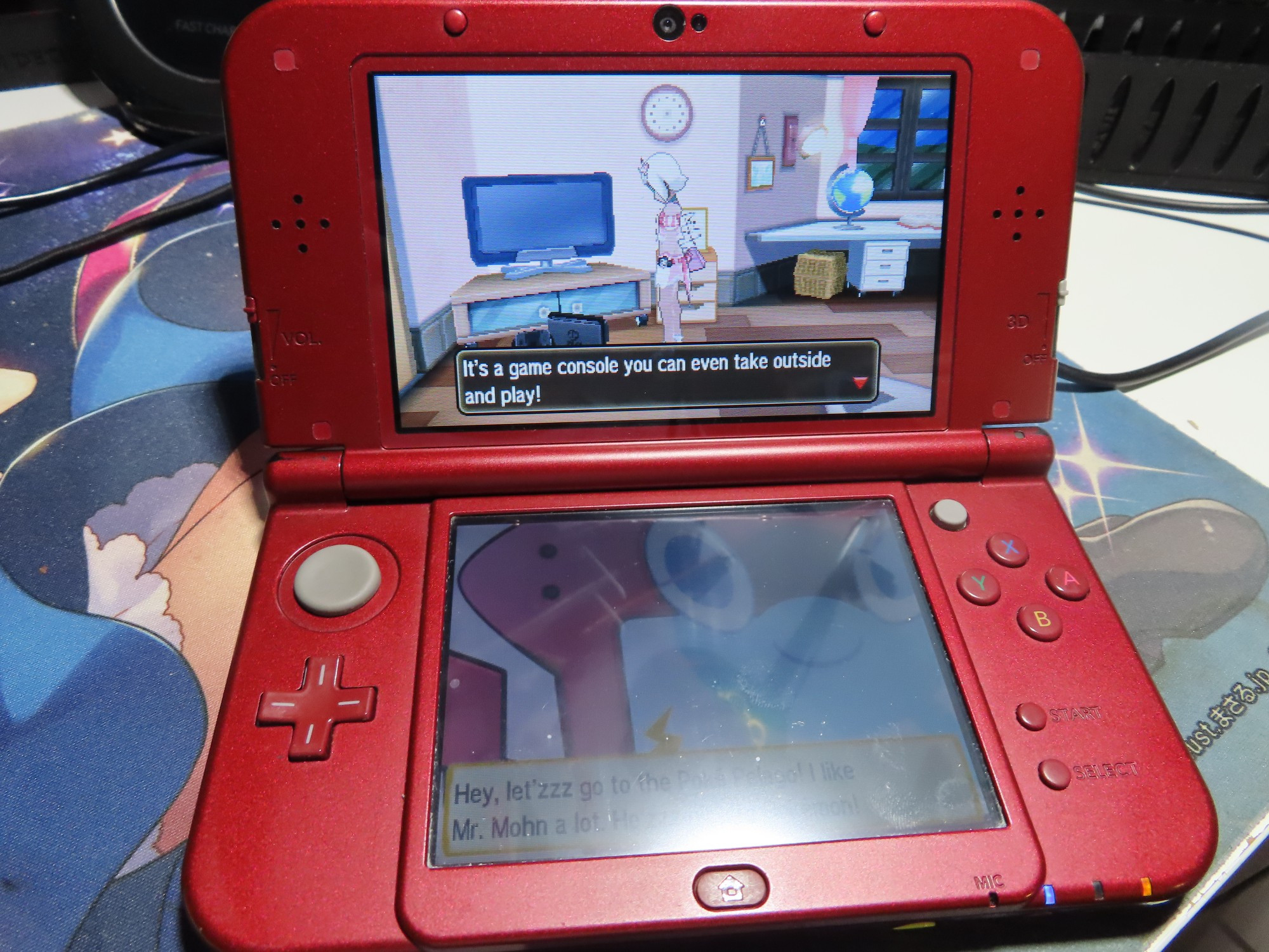 An image of a 3DS that is current playing Pokemon: Ultra Moon. The main player character is in her room, looking down at a Nintendo Switch that is currently docked. The dialog box says, "It's a game console you can even take outside and play!"

There is also Rotomdex that is trying to say something but is not relevant for the illustration.