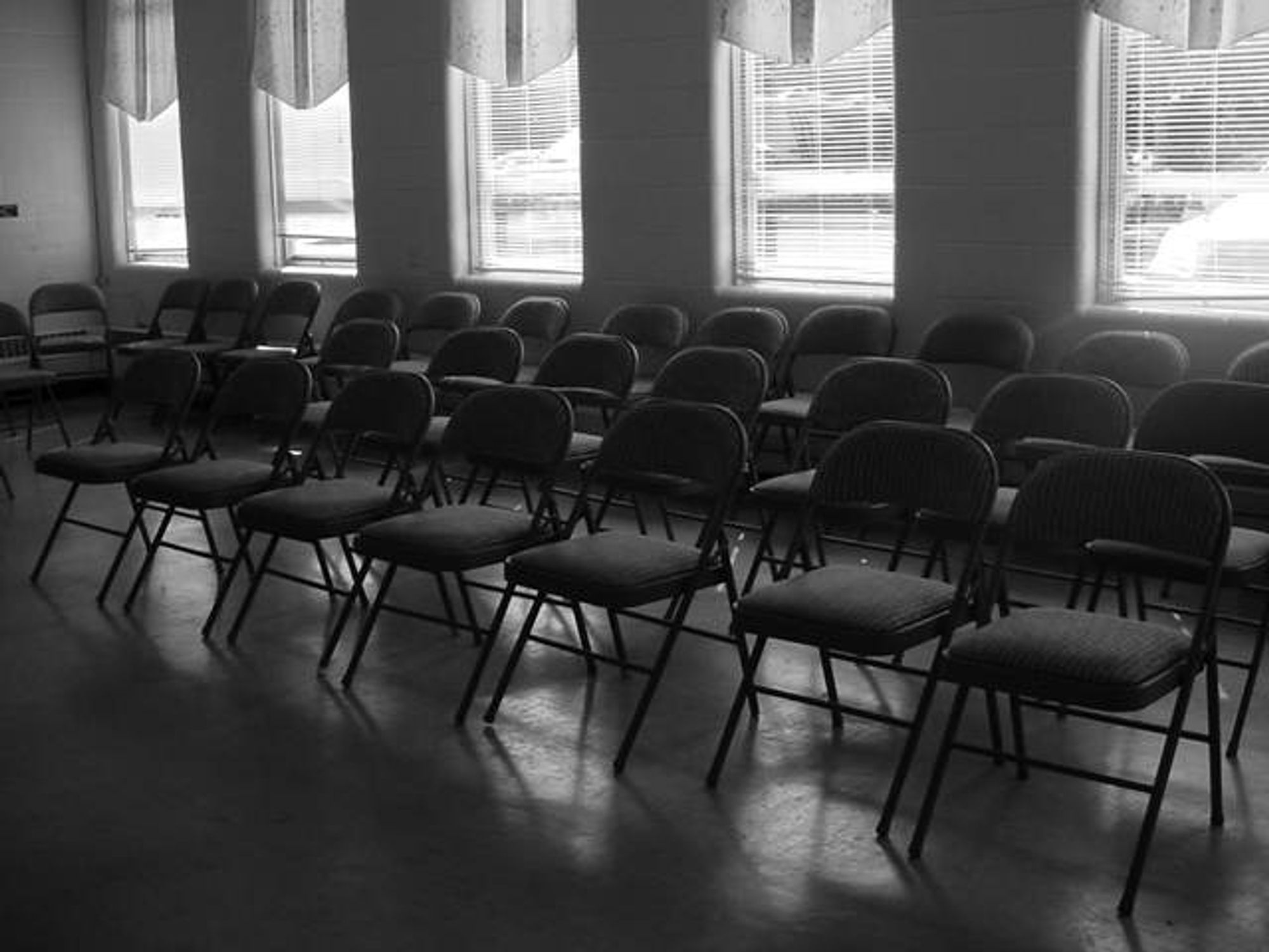 A set of folding chairs set up in rows, with five windows behind it.

This was taken with the black and white setting on a Sony Mavica MVC-FD200, the infamous floppy disk camera.