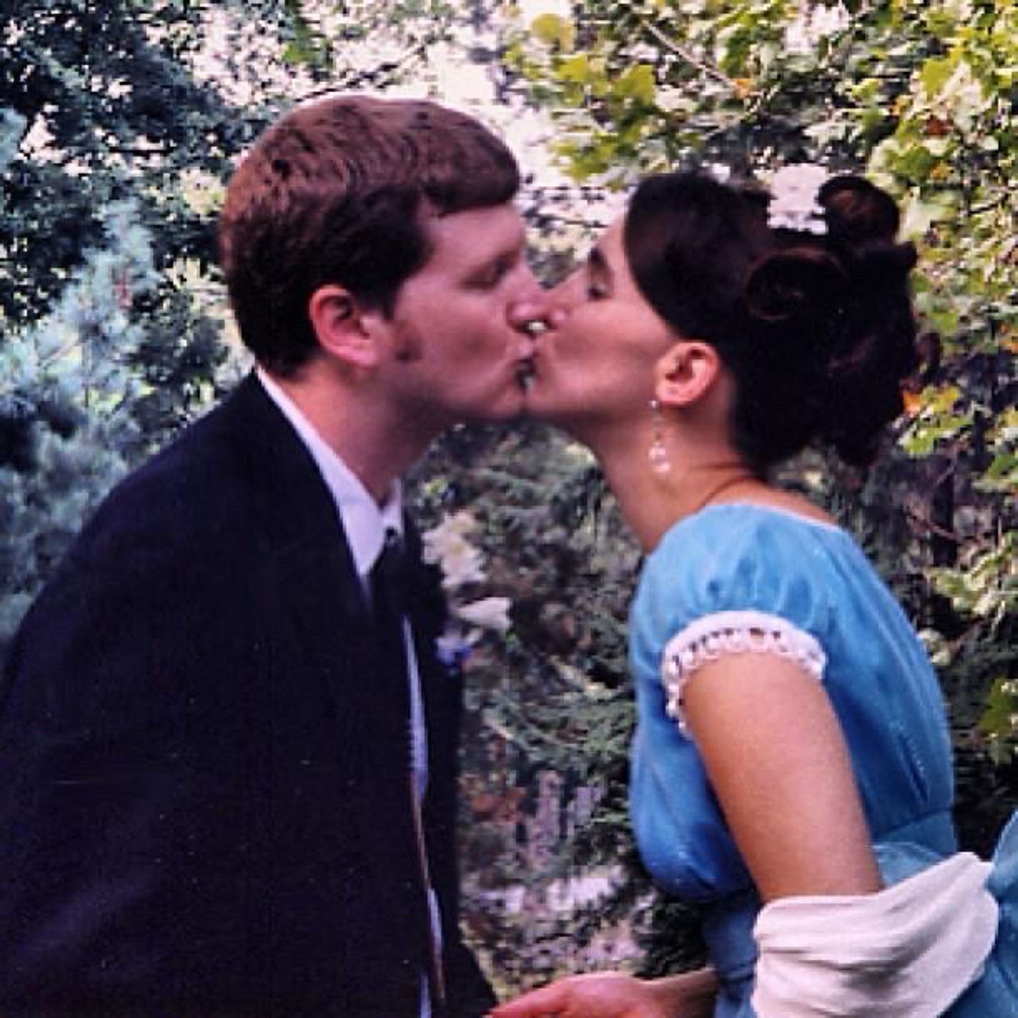 A couple kissing in NYC’s Central Park on their wedding day 26 years ago