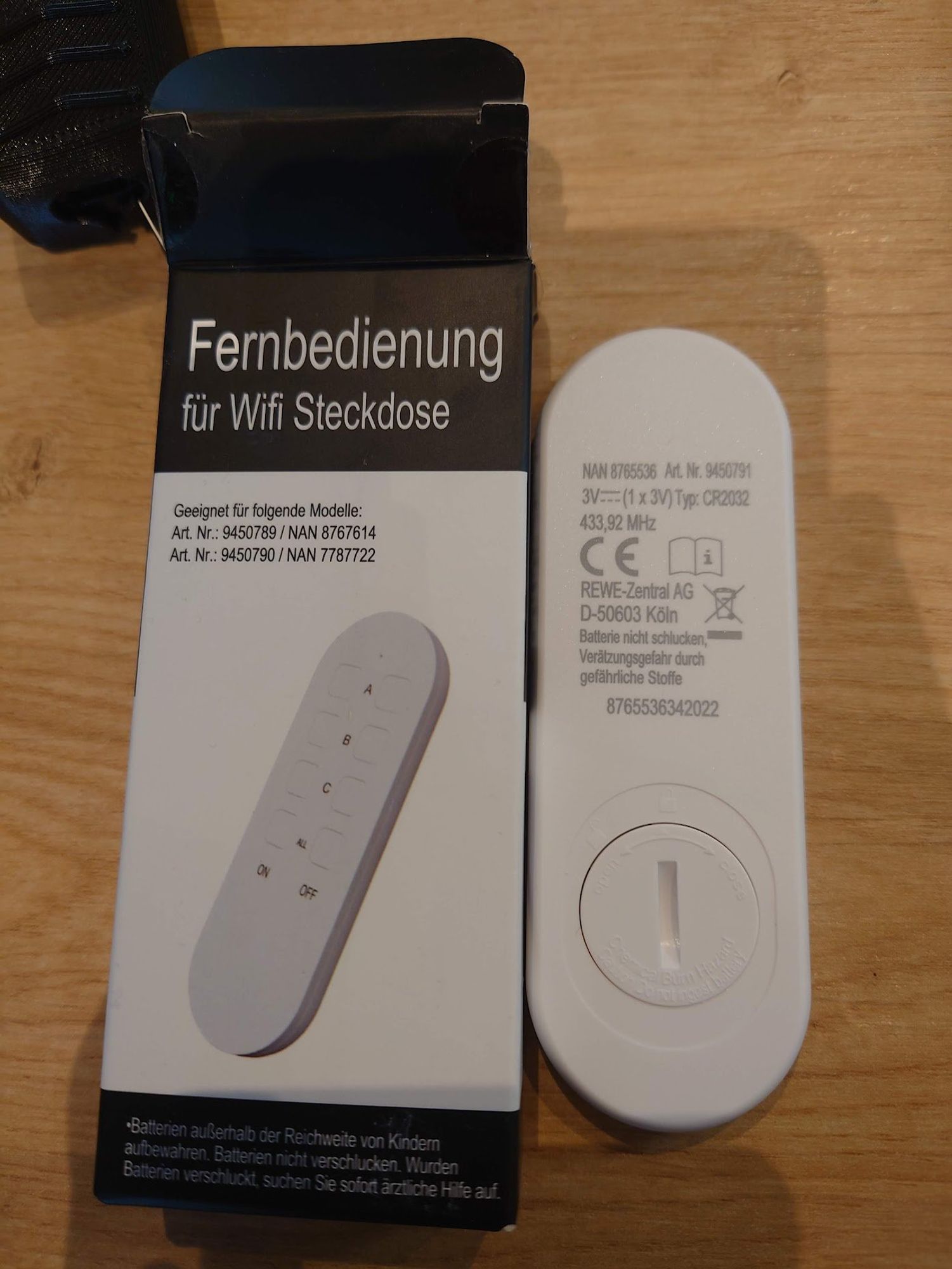 The packaging of a "Remote for Wifi plug" and the remote next to it. The back of the remote has "433.92MHz" printed on it alongside some other information. The packaging makes no mention of the frequency, leading one to assume it works on 2.4Ghz Wifi