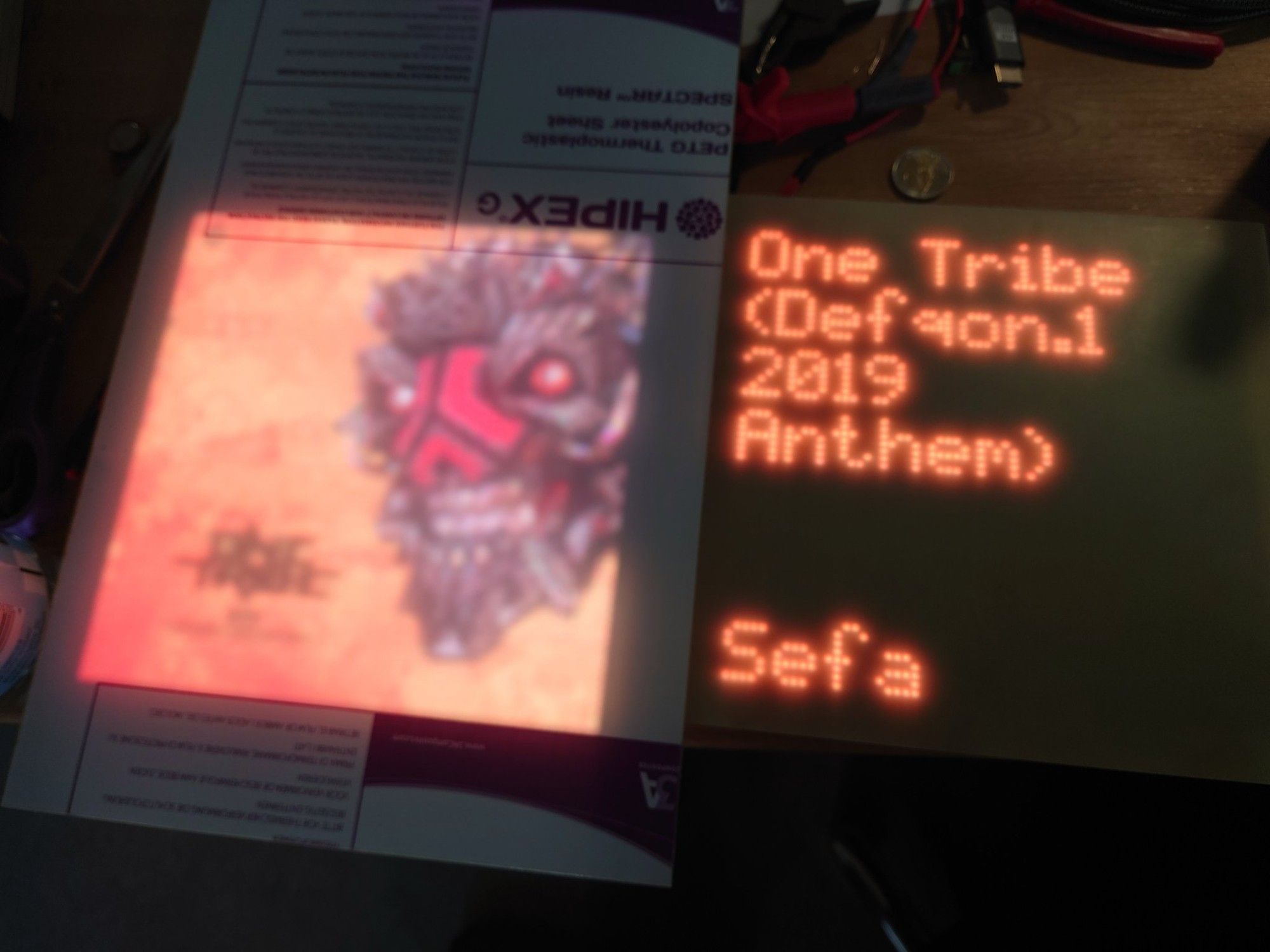 Two pixel displays, the left one displaying an album cover and the right one the track name and artist.