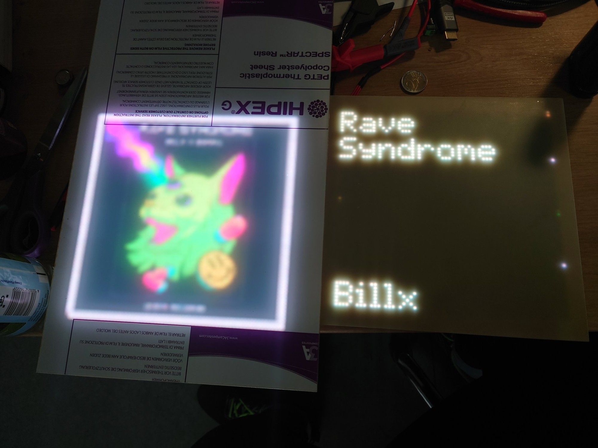 Two pixel displays, the left one displaying an album cover and the right one the track name and artist.