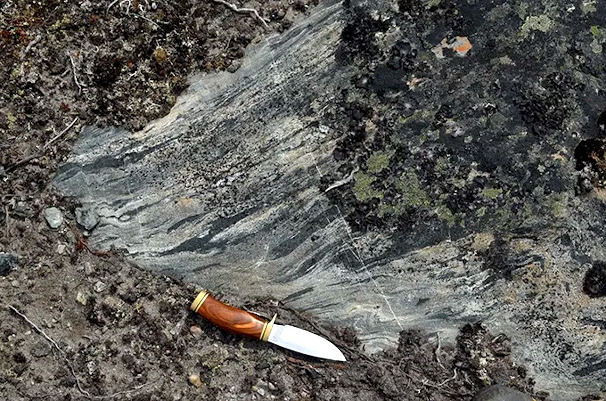 An ancient intrusion of magma (the striated rocks at center) in the Nuvvuagittuq Greenstone Belt is 4.16 billion years old, researchers say. Credit: Jonathan O’Neil