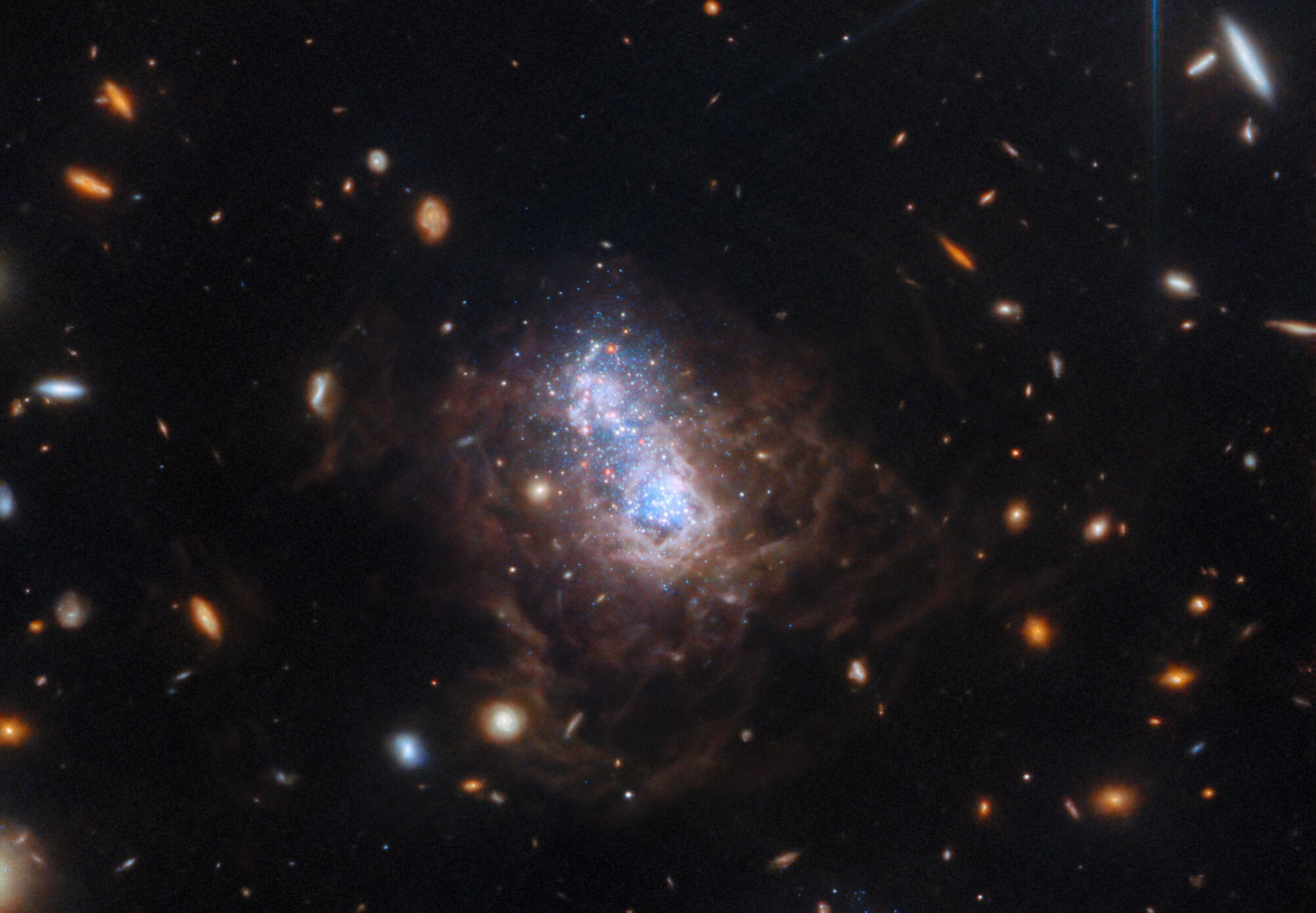 The NASA/ESA/CSA James Webb Space Telescope has captured a spectacular view of the galaxy I Zwicky 18 (I Zw 18) in this new image. The galaxy was first identified by Swiss astronomer Fritz Zwicky in the 1930’s and resides roughly 59 million light-years from Earth. This galaxy has gone through several sudden bursts of star formation. This galaxy is typical of the kinds of galaxies that inhabited the early Universe and it is classified as a dwarf irregular galaxy (much smaller than our Milky Way).