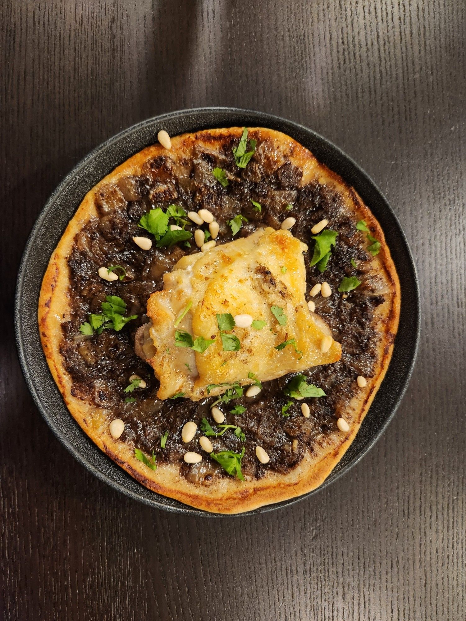 Plate of musakhan, a Palestinian dish of flatbread topped with sumac onions and chicken.