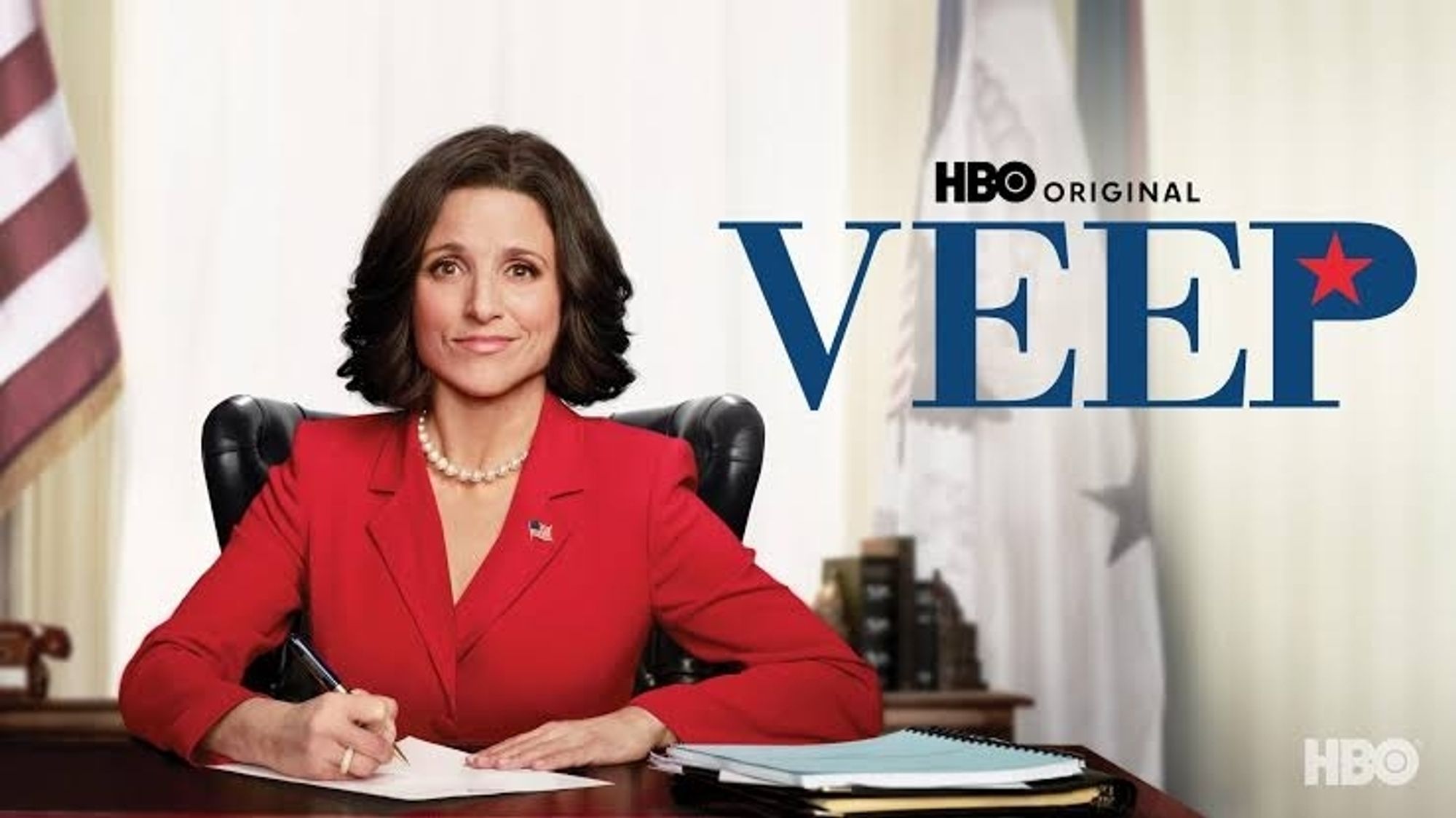 Poster de divulgação da série Veep, com a Júlia Louis-Dreyfus com um terno vermelho belíssimo, sentada à mesa presidencial americana, assinando algum documento e olhando pra câmera. Eu preciso ver e sei que ficarei totalmente obcecada pela série, afinal, Julia Louis-Dreyfus