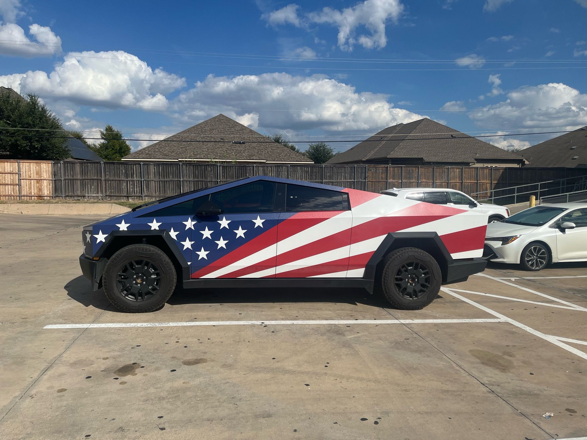 A cybertruck wrapped with an American flag