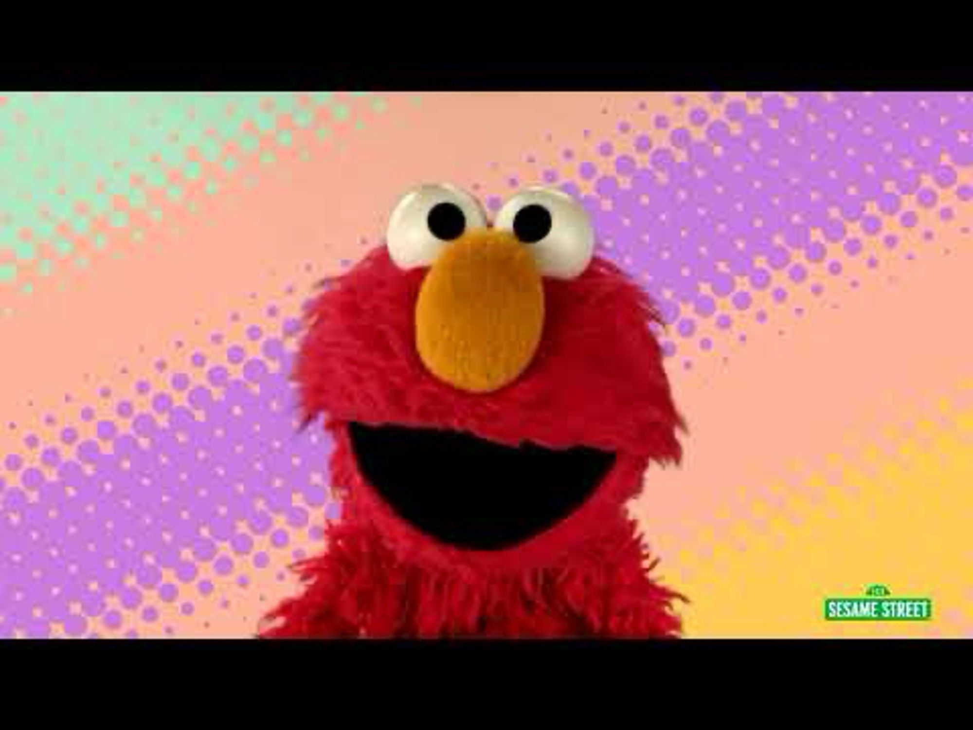 Elmo smiling close up with vividly coloured background