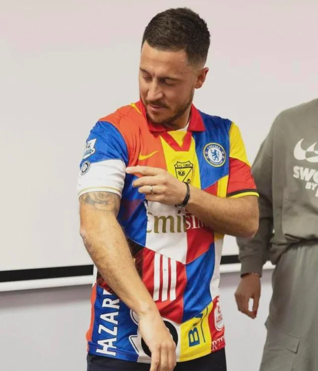 Footballer Eden Hazard wearing a shirt that contains a bit of every club he has played for.