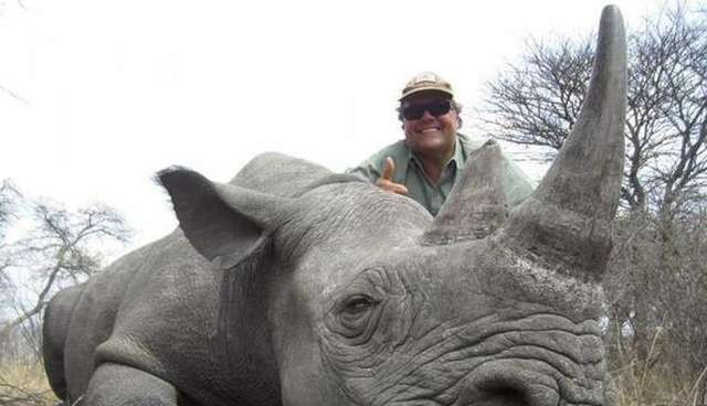 Photo of Jimmy John's owner posing with rhino he killed.  One among many endangered species.