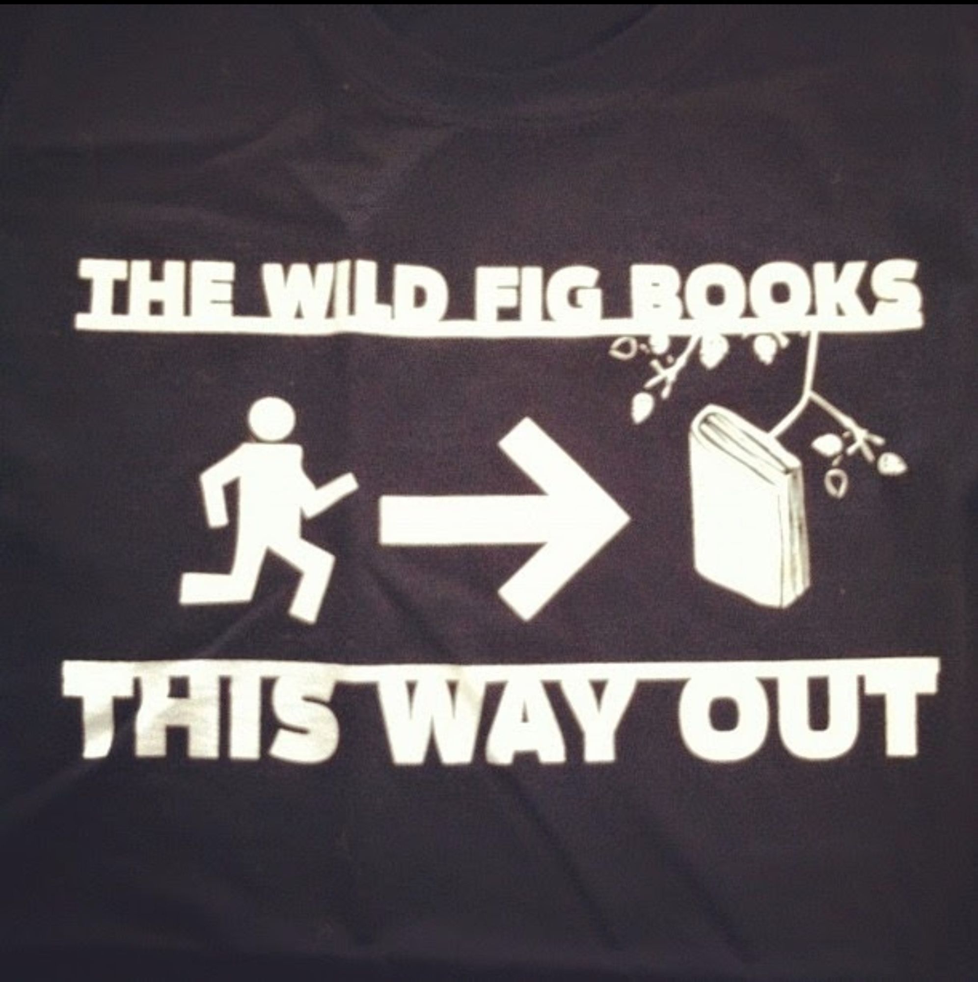 black and white tee shirt illistration of a figure running towards an exit shaped as the wild fig logo with text that reads this way out.