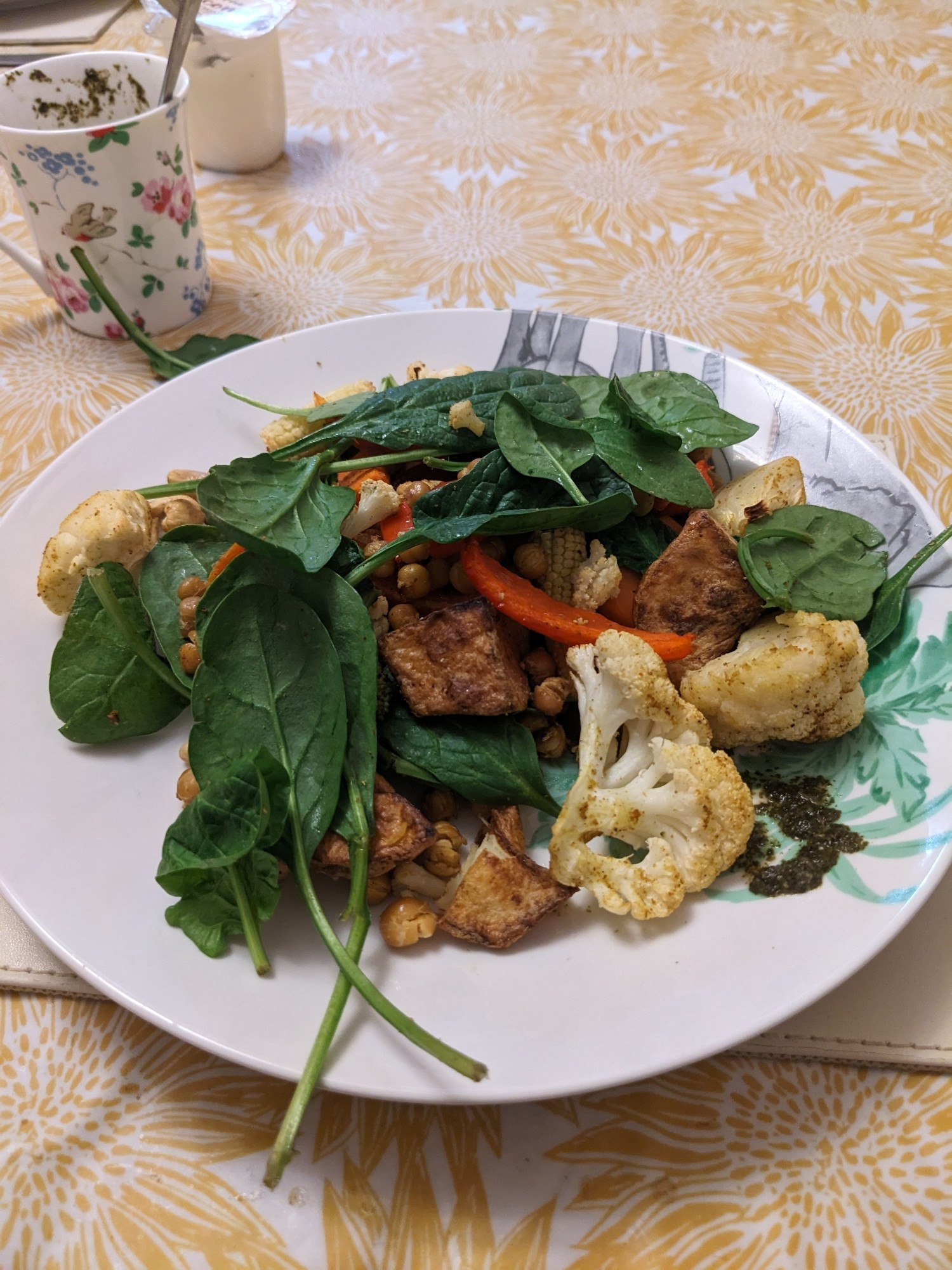 Spiced cauliflower and other roasted veggies including pepper, onions, carrots and baby sweetcorn. Also roasted potatoes, chickpeas and cashews and topped with fresh spinach.