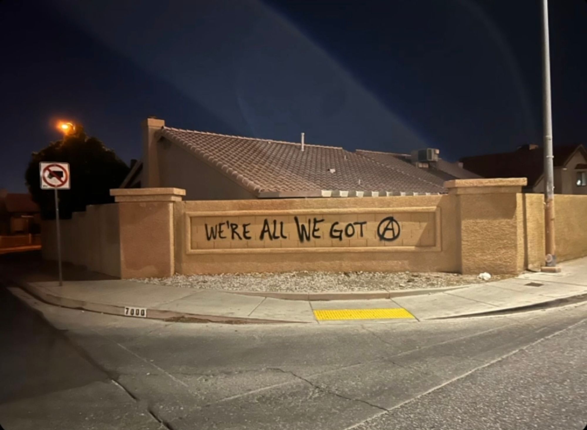 "We're all we got" written on a wall with black spray paint