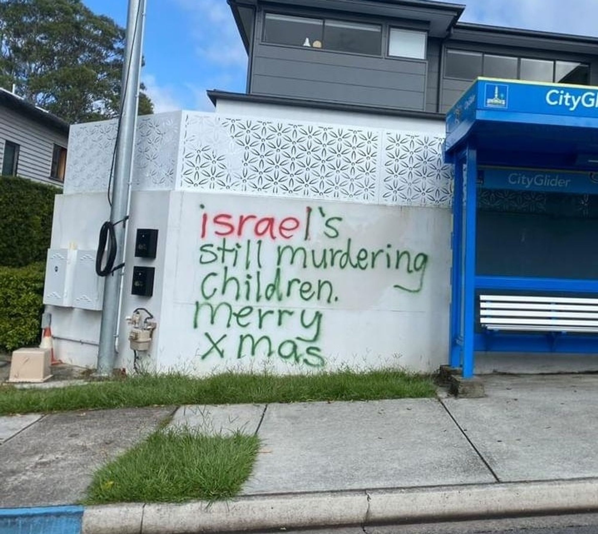 "Israel's still murdering children. Merry Xmas" written on a wall with red and green spray paint