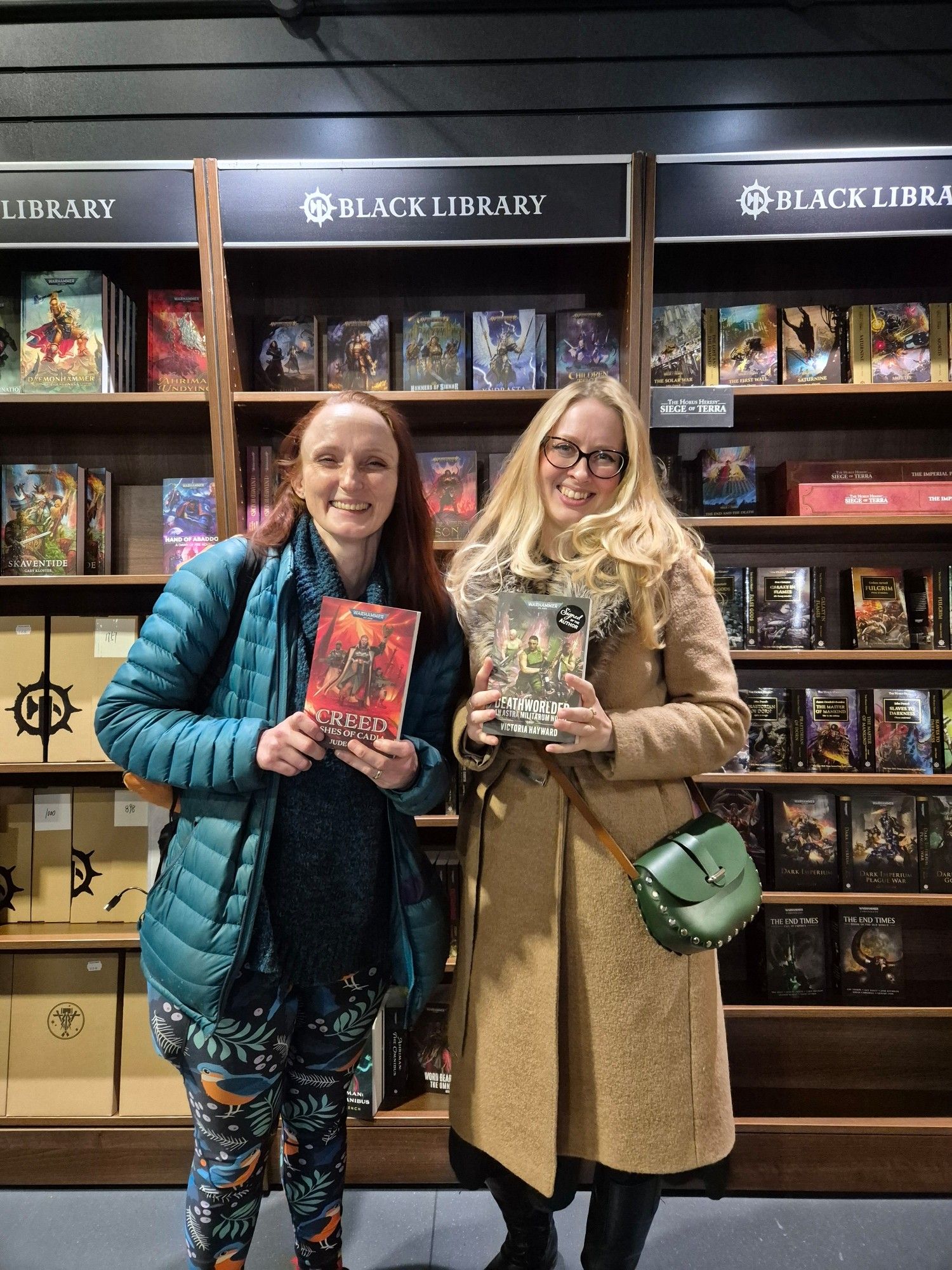 Tory Hayward and Jude Reid holding copies of their books at Warhammer World