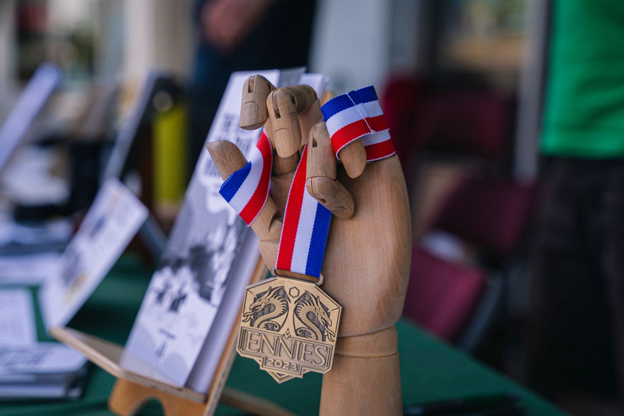 A mannequin hand holds a Ennie 2023 award.