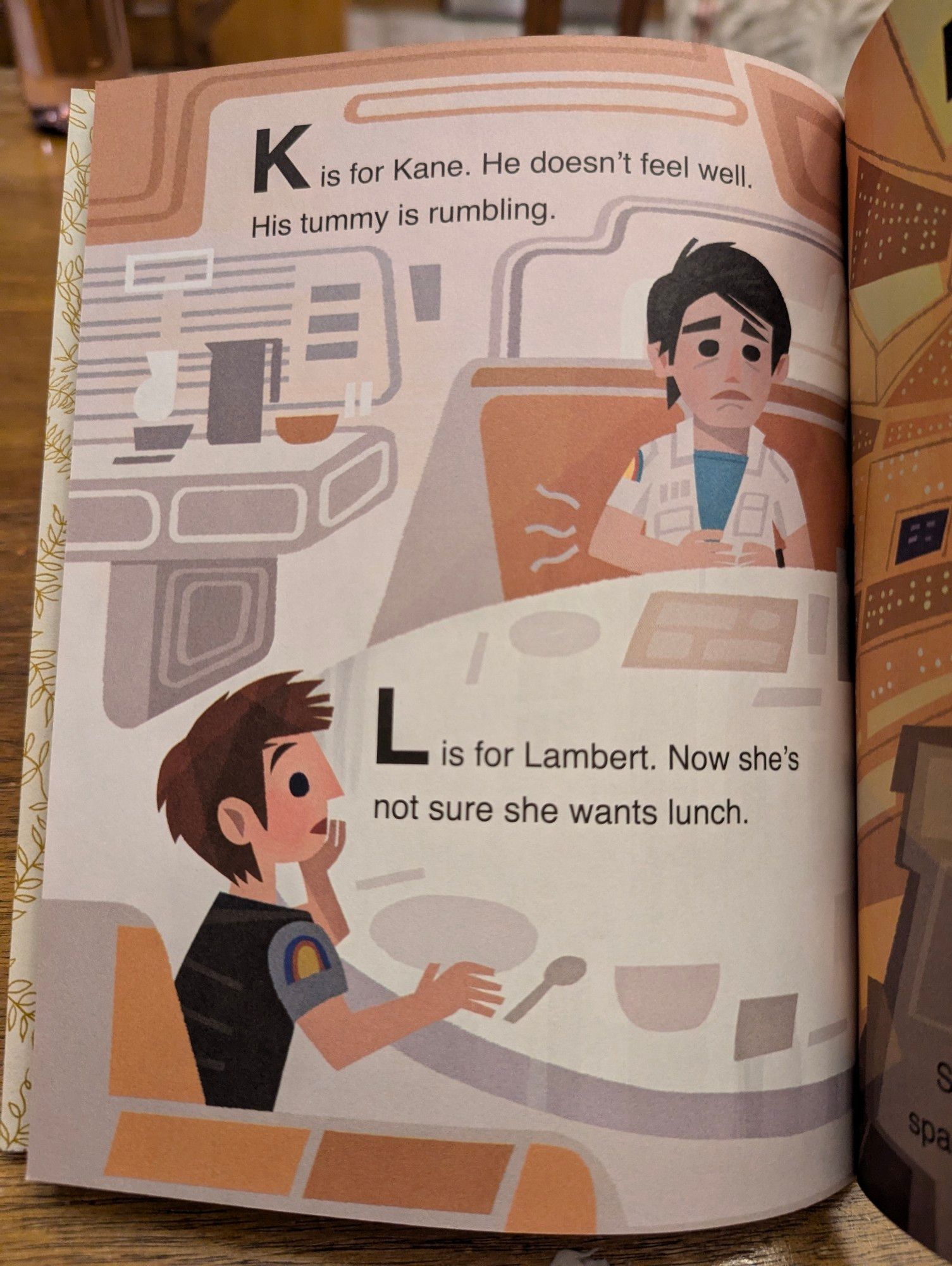 K is for Kane. He doesn't feel well. His tummy is rumbling.

L is for Lambert. Now she's not sure she wants lunch.