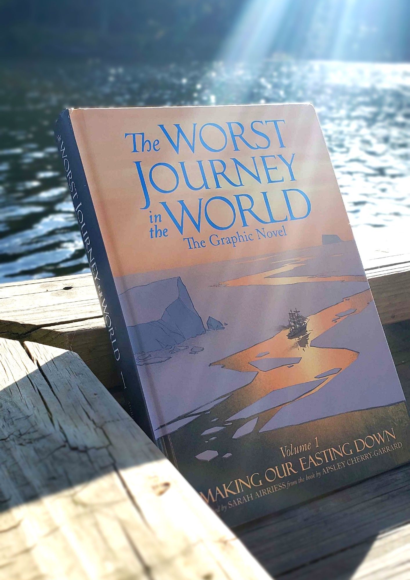 The Worst Journey In the World, adapted by Sarah Airriess from the book by Apsley Cherry-Garrard sits upon a dock hoping to entice you to be hungry enough to see the sea. The book features a cover with a large sailing-engine ship that is sneaking through a melted strait in a large sheet of ice over the ocean

You can pick up a copy of this hardcover graphic novel here, https://www.cbsd.com/9781638991373/

 We can guarantee you will not regret it. While there's 150 pages of novel you'll look the fine details of over for weeks, Sarah has done so much research on her own which you can see in 70 pages of annotations!