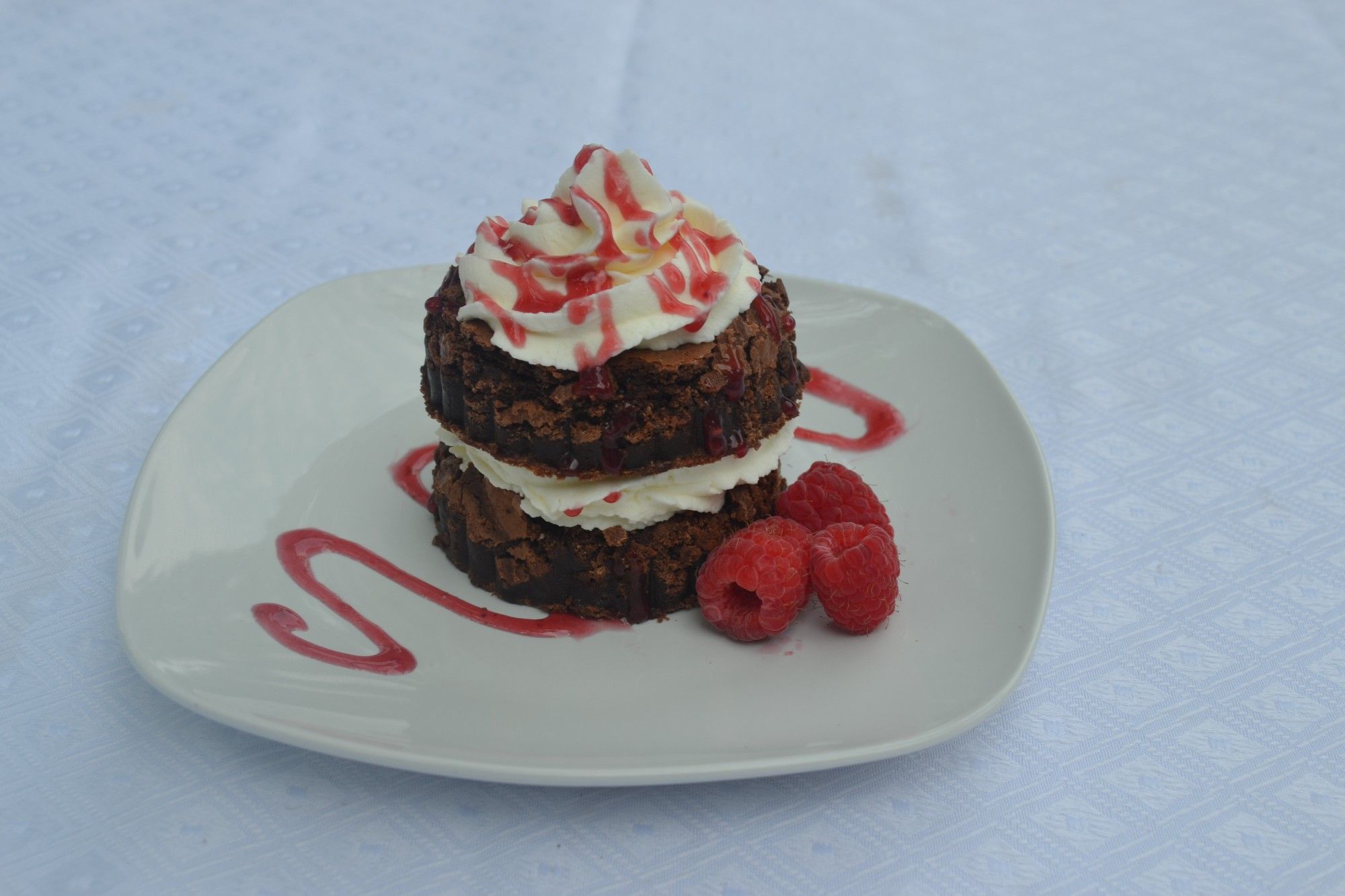 Brownie with stabalized whipped cream and raspberry sauce!