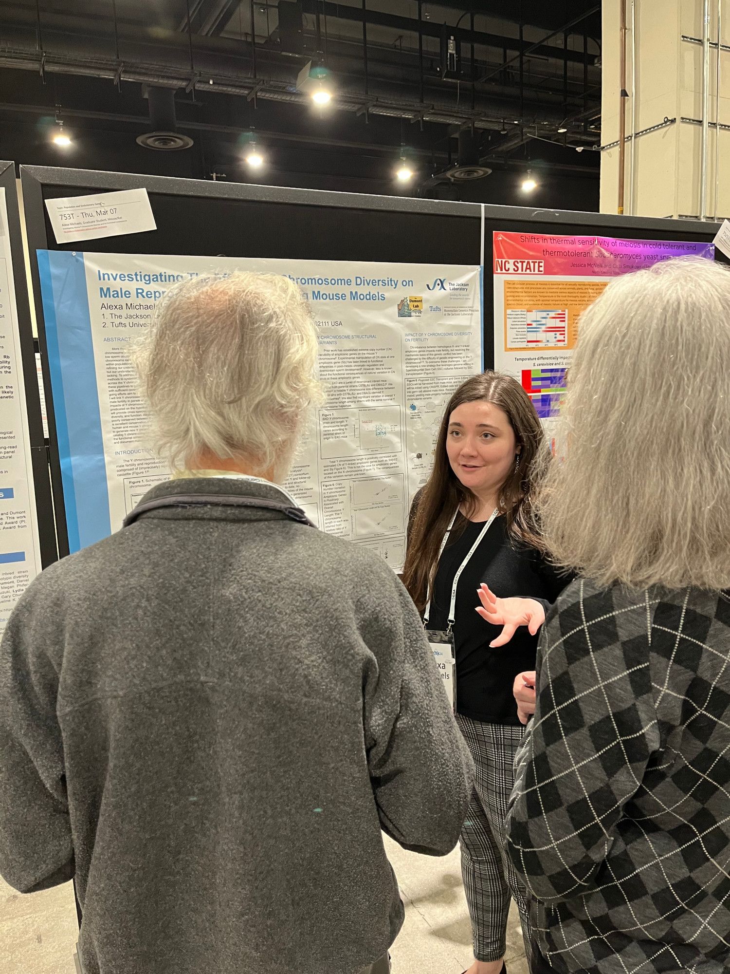 Alexa Michaels explains a research poster to fellow TAGC conference attendees.