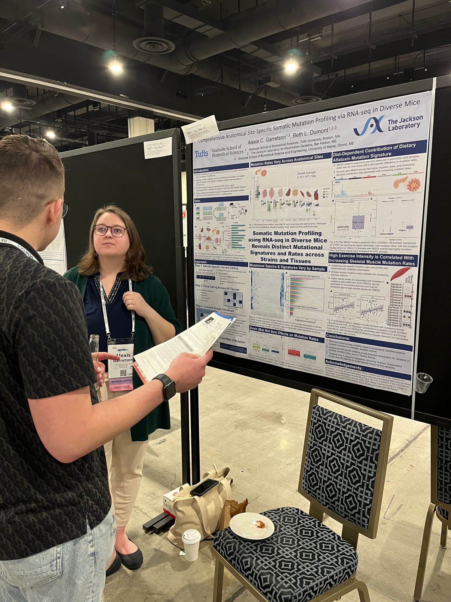 Alexis Garretson explains a research poster to fellow TAGC conference attendees.