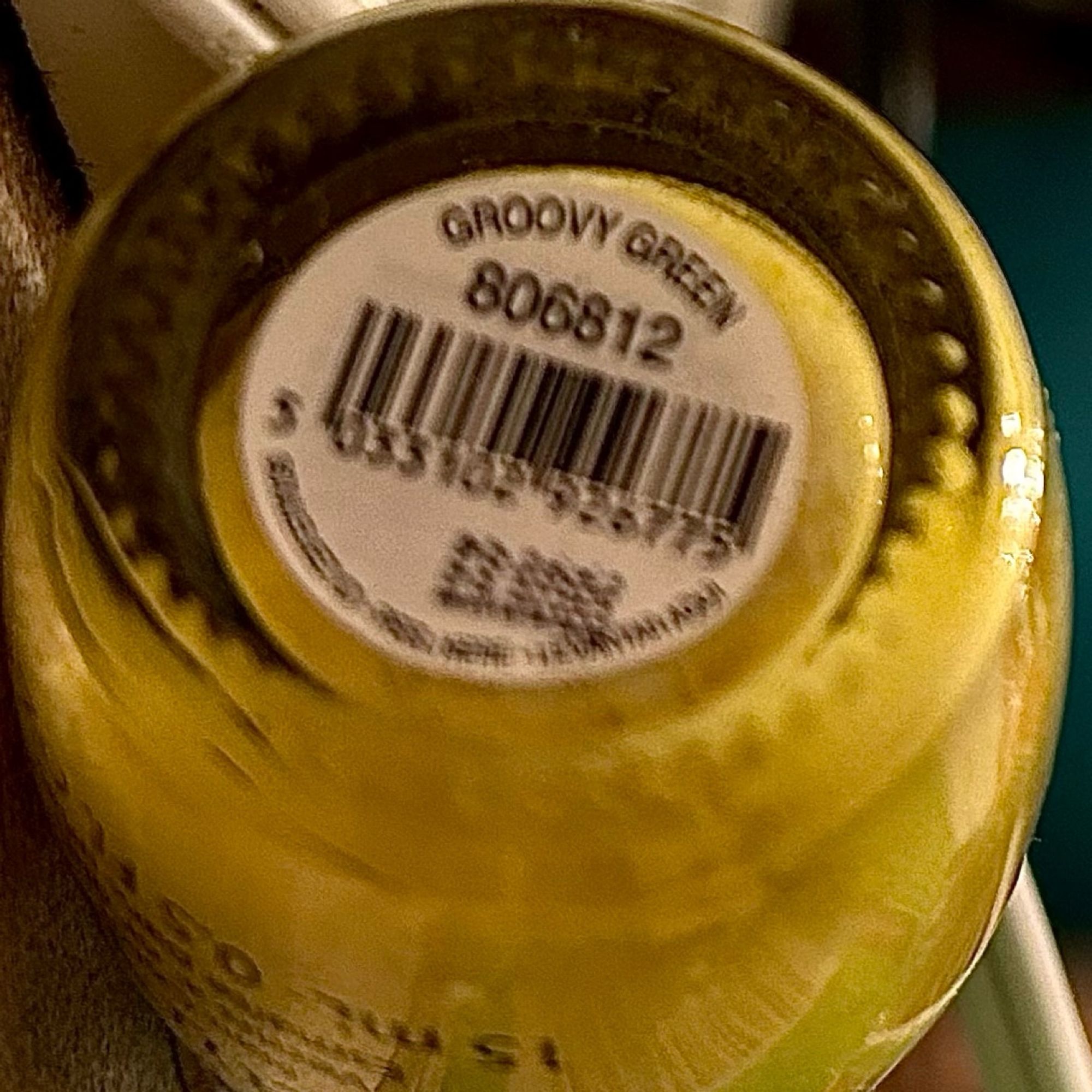 Small glass bottle with groovy green polish inside. It’s upside down and the label is white with a black bar code, a product number, and “GROOVY GREEN” (I say yeah, baby yeah)