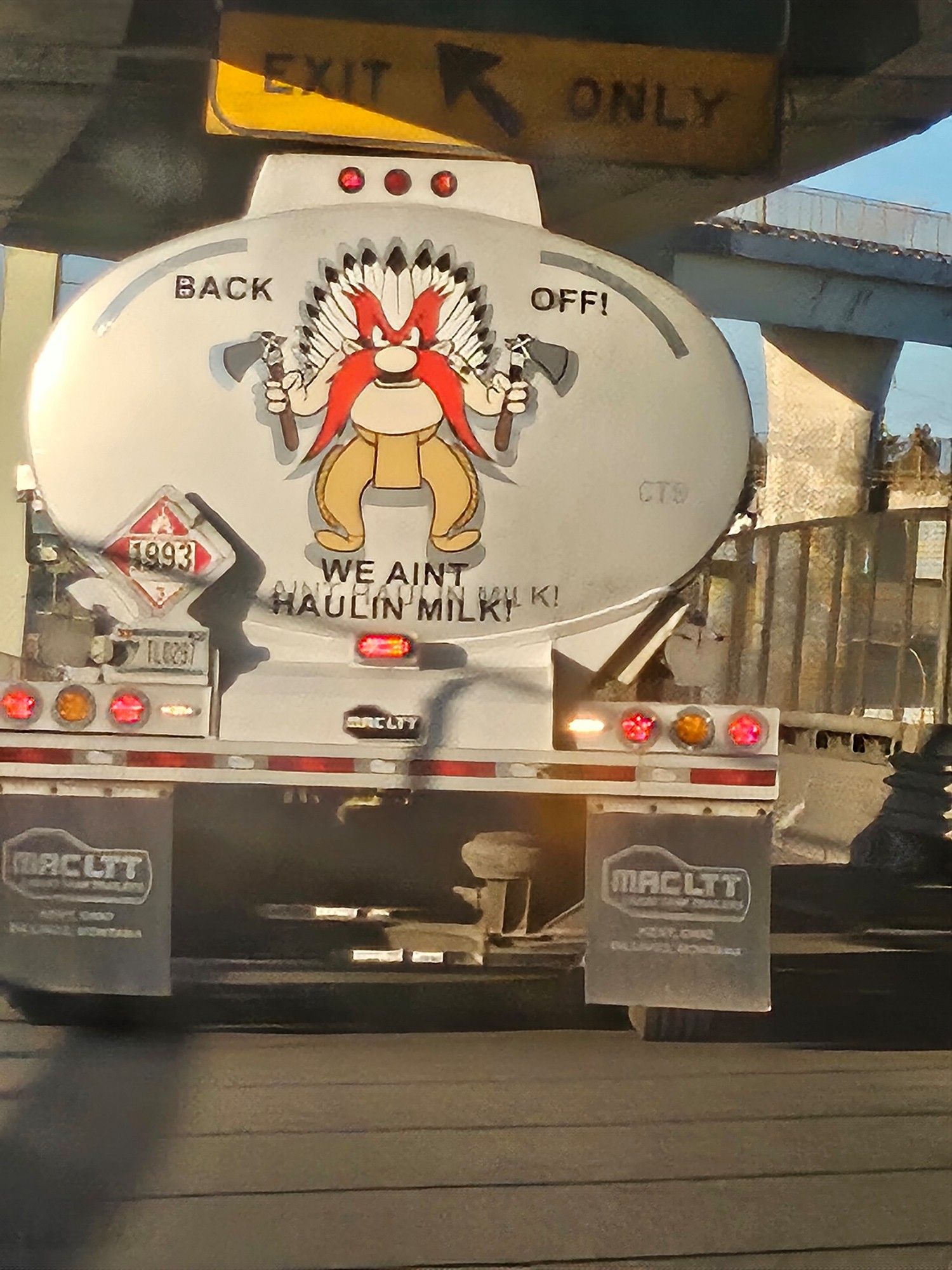 The back of tank trunk bearing an image of Yosemite Sam wearing a stereotype Souix feather war bonnet and holding a tomahawk in each hand, with the caption "BACK OFF! WE AIN'T HAULING MILK"