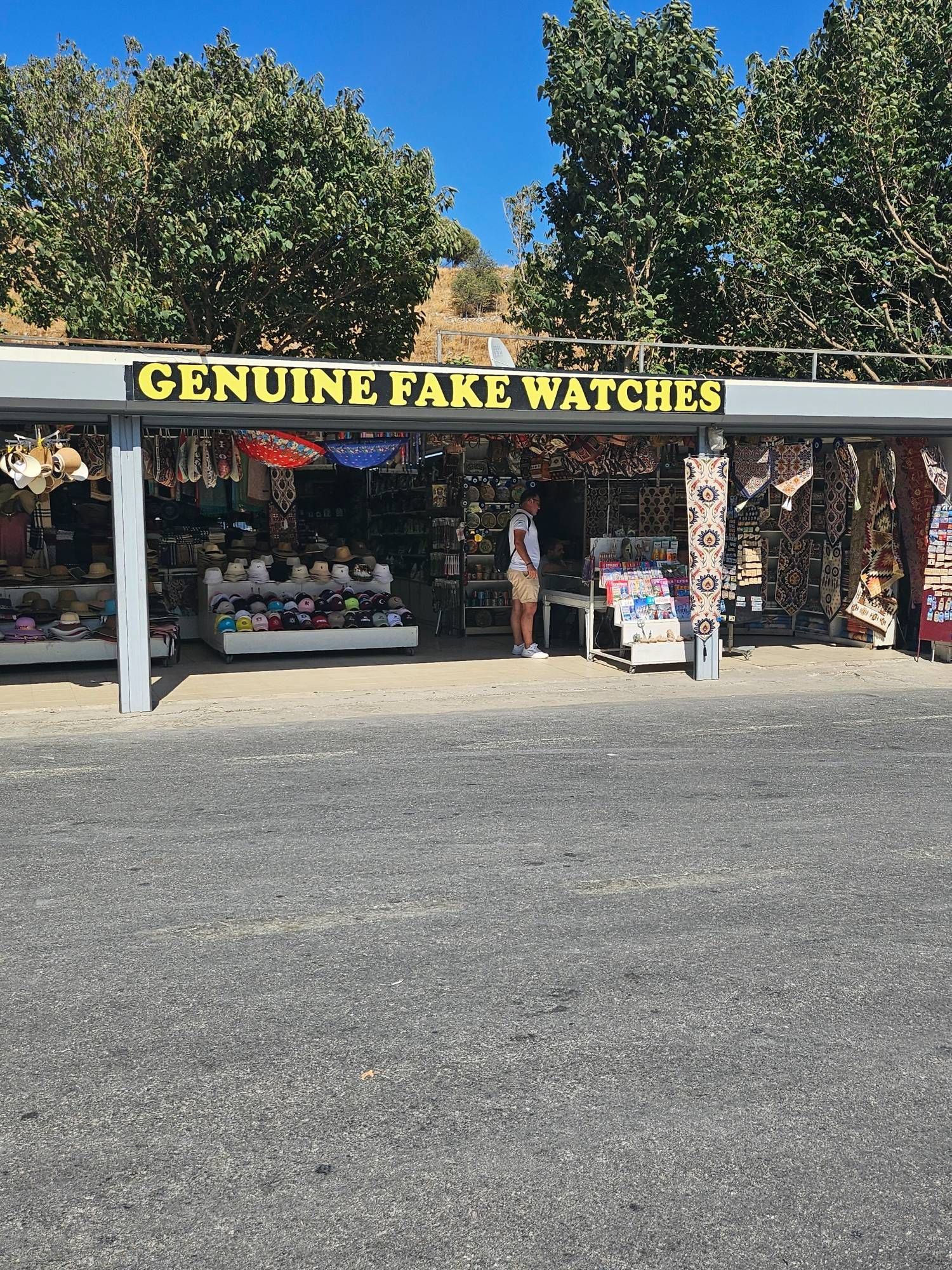 A tourist souvenir shop with a large sign reading "GENUINE FAKE WATCHES" although the shop didn't seem to sell watches at all.