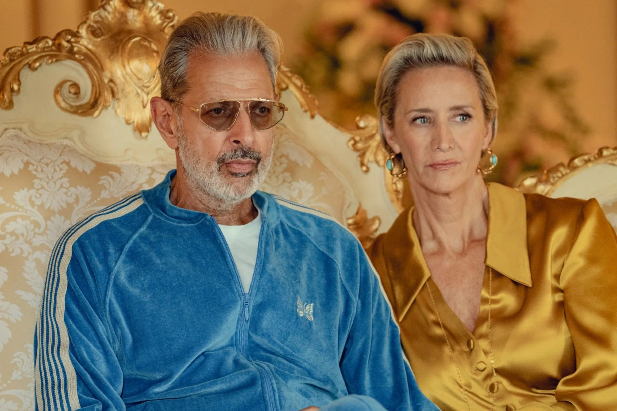 Jeff Goldblum as Zeus in Netflix's Kaos, resplendent in a velour Needles tracksuit and vintage Jacque Marie Mage sunglasses. Beside him is Janet McTeer as Hera, in a gold blouse.