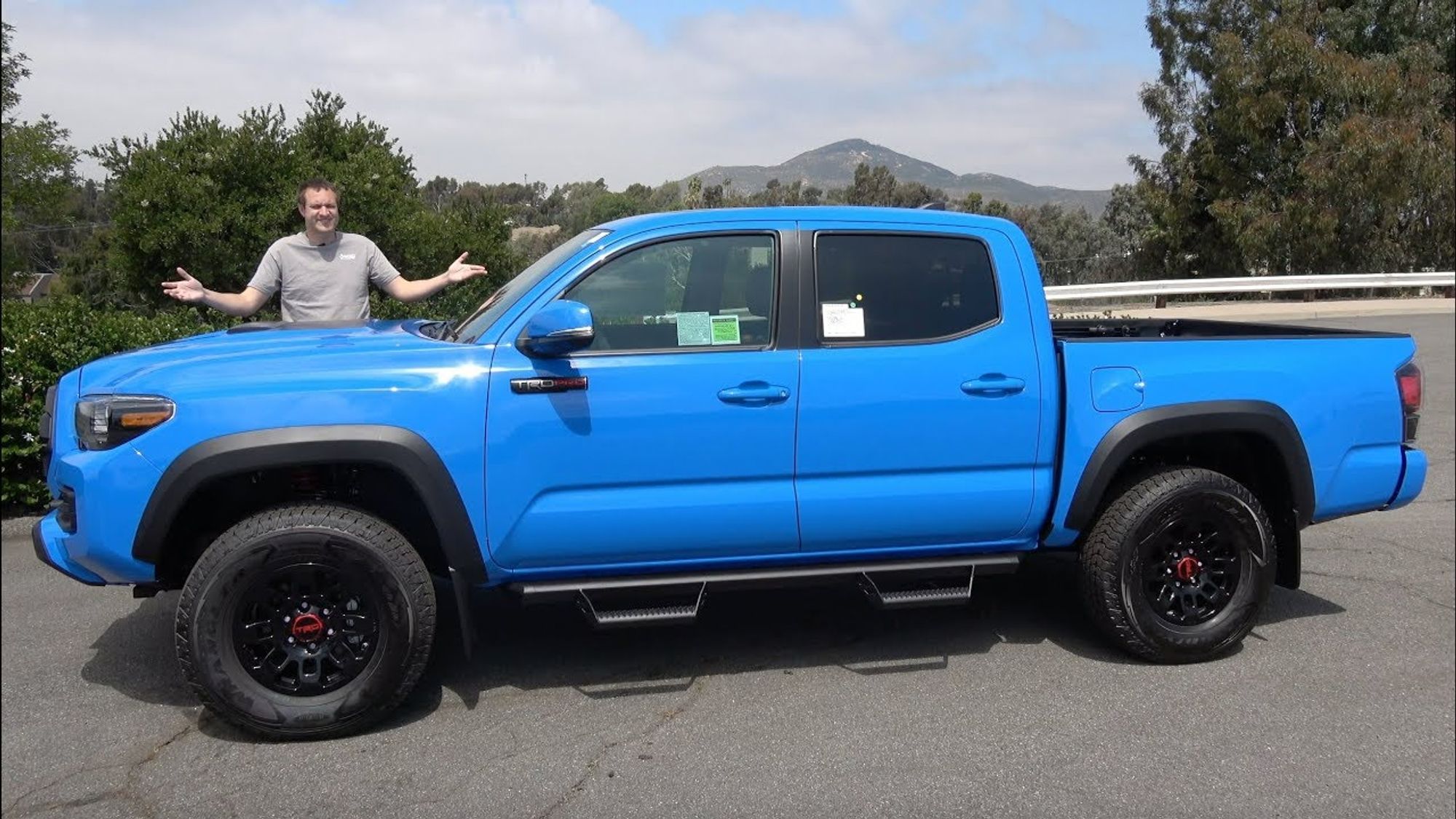 A thrid gen Tacoma with Doug behind it, showing how much longer and higher the hood is than on the Hilux