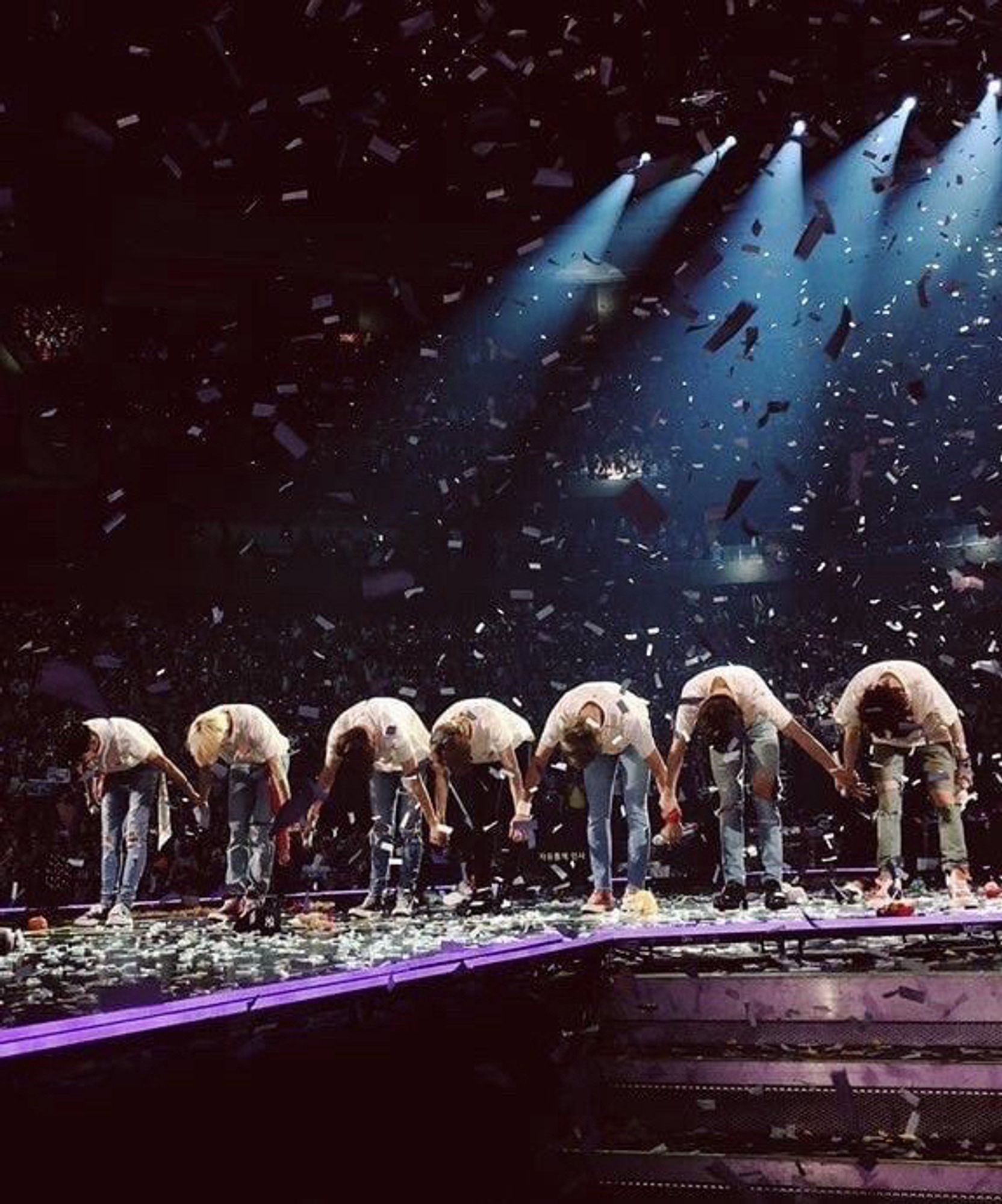 BTS concert picture with them holding hands and bowing in a gesture of love and respect 💜