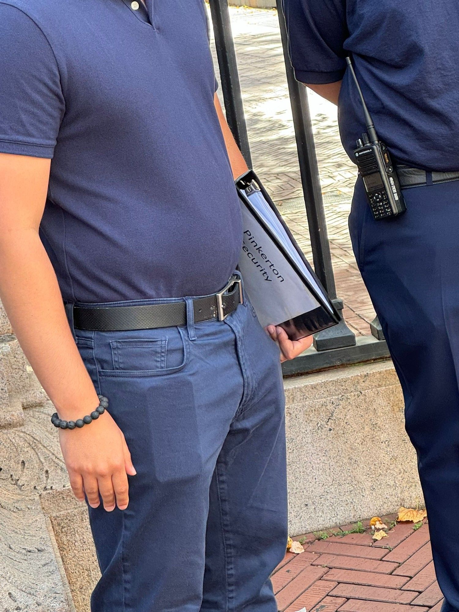 man holding a binder that says 'pinkerton security'