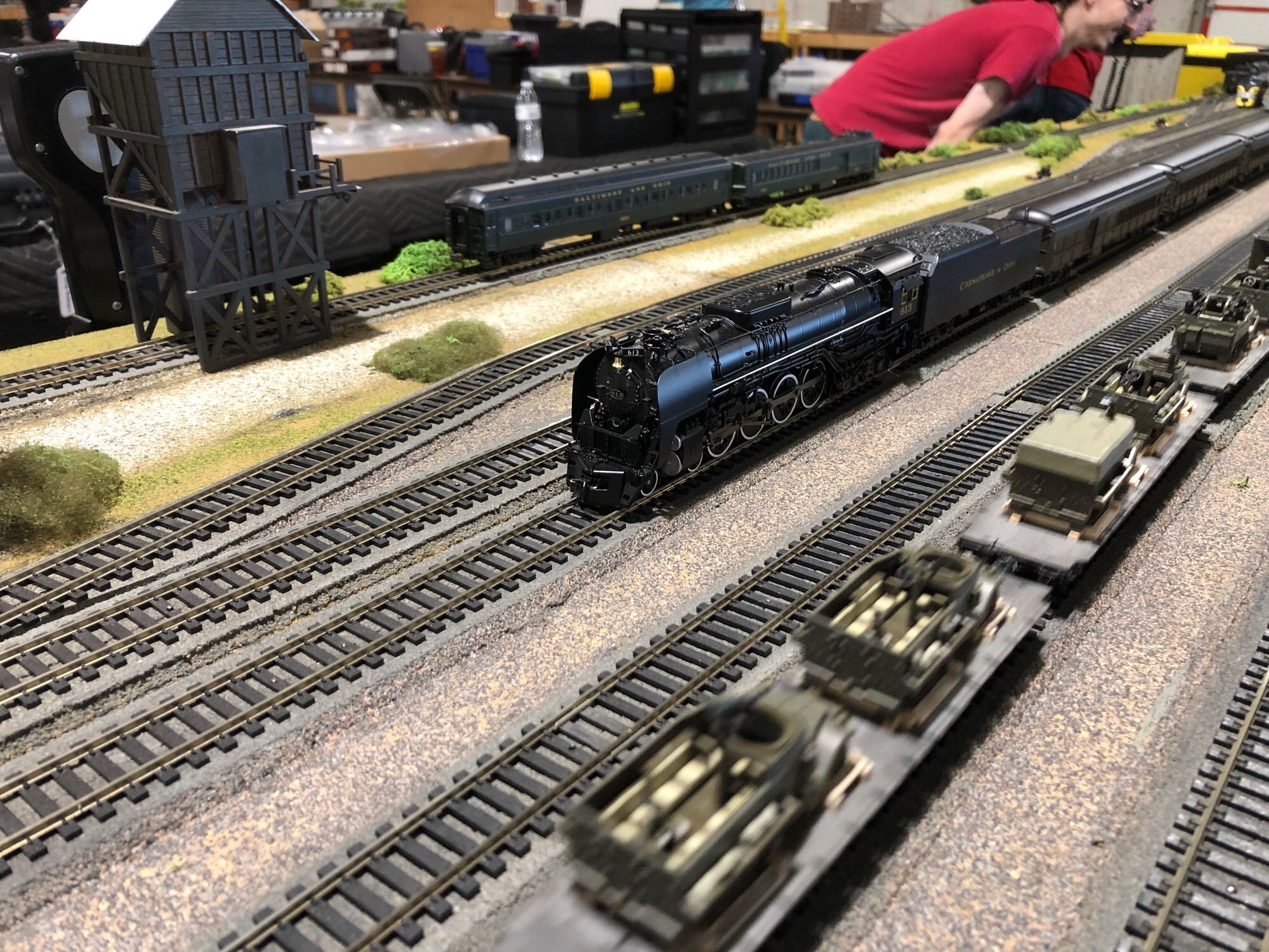 The throat of the Union Station approach, where Chesapeake and Ohio 4-8-4 613 sits with the George Washington consist waiting to depart. A US WWII troop train with flat cars full of half tracks is passing by in the foreground (blurred)