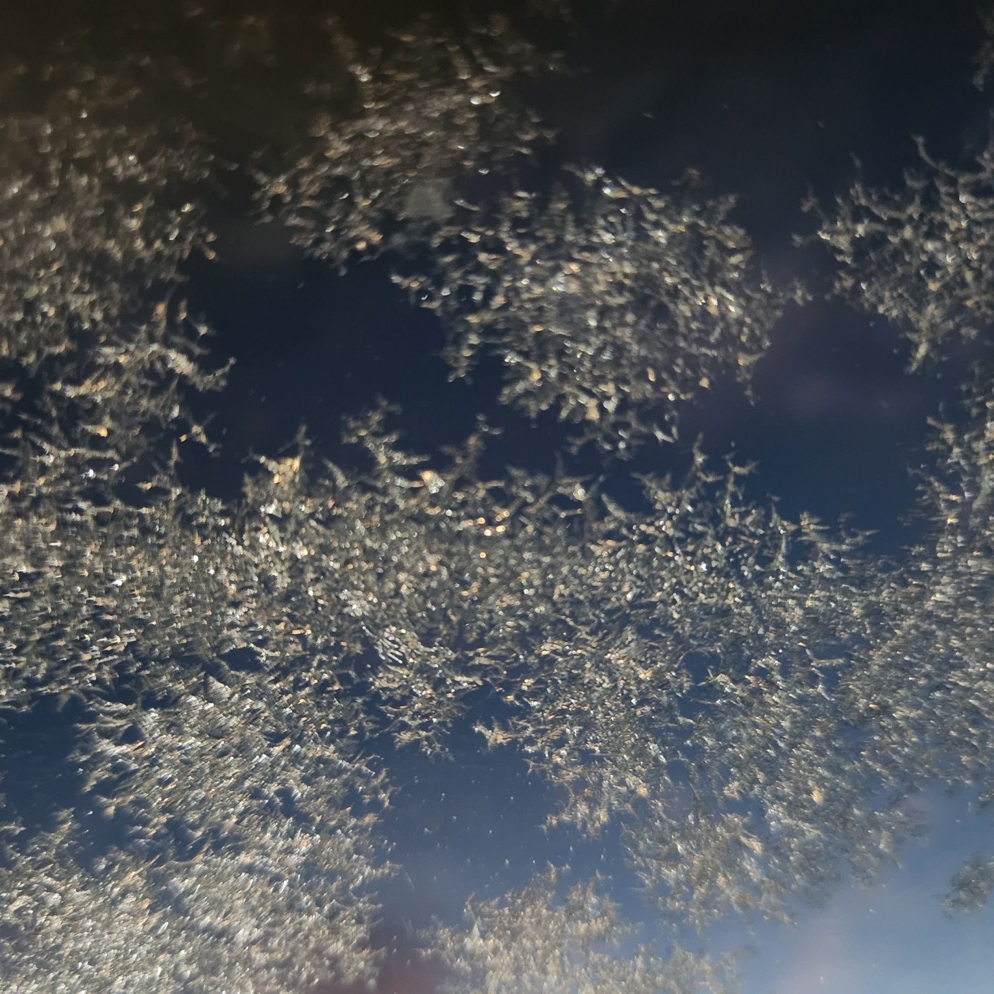 Frosty windshield with blue morning sky in the background