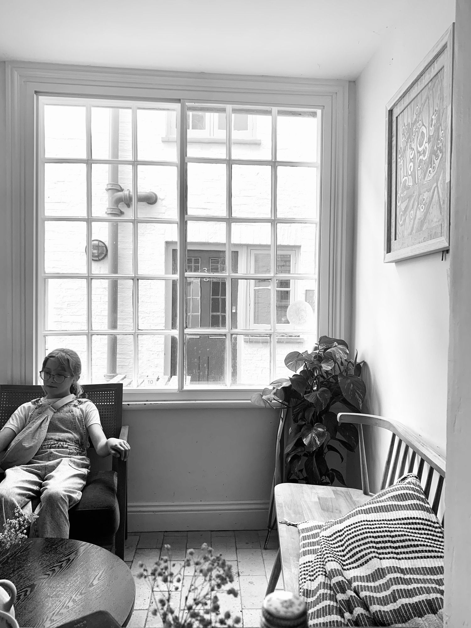 Picture inside a coffee shop looking up at a window and out to the street where it’s raining, the window is made up of 30 small panes, there is a girl sitting near the window, light floods through.  Yes I ate a beautiful lemon cake.