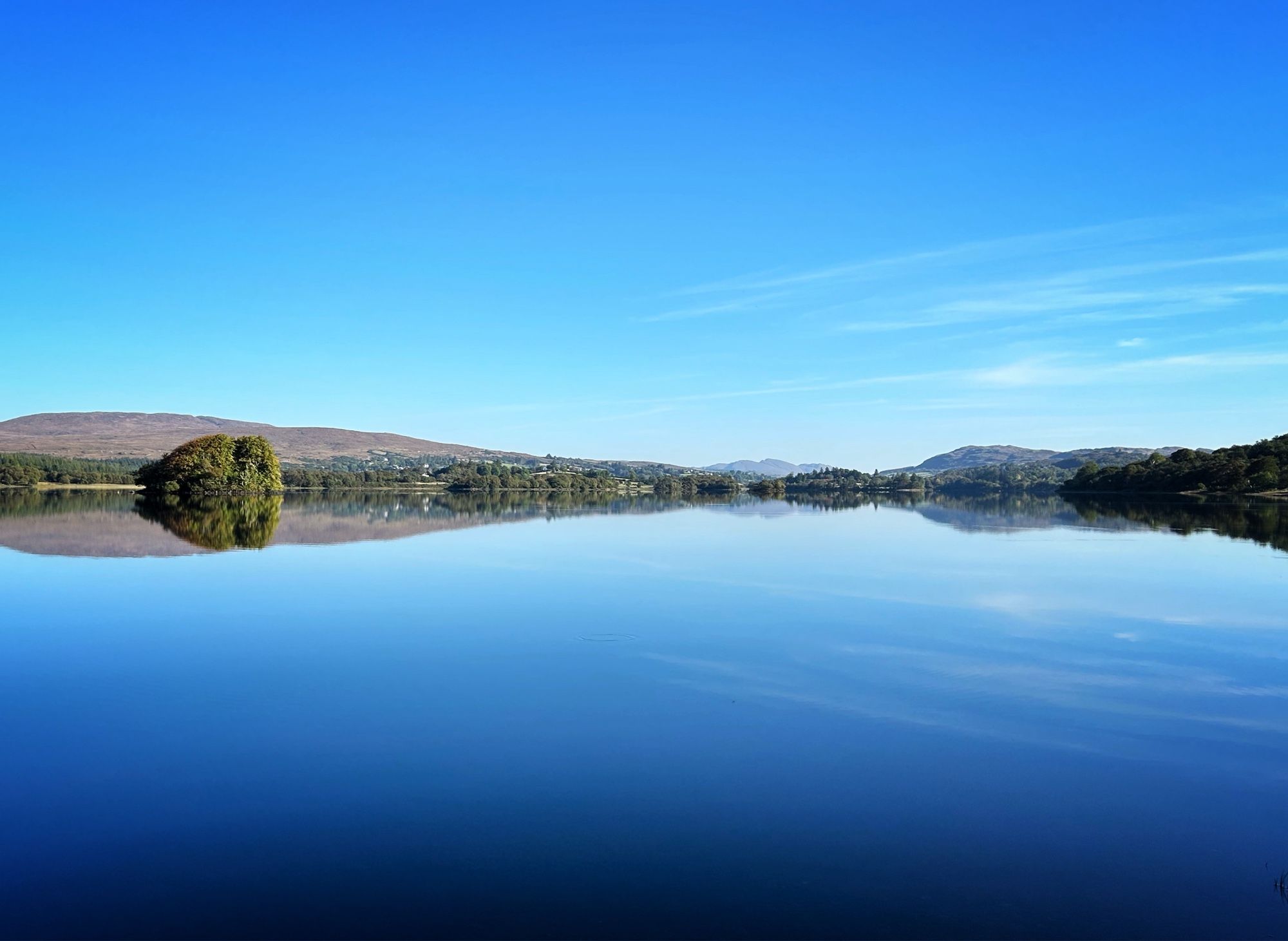 Reflection in a lake. Blue sky and water.