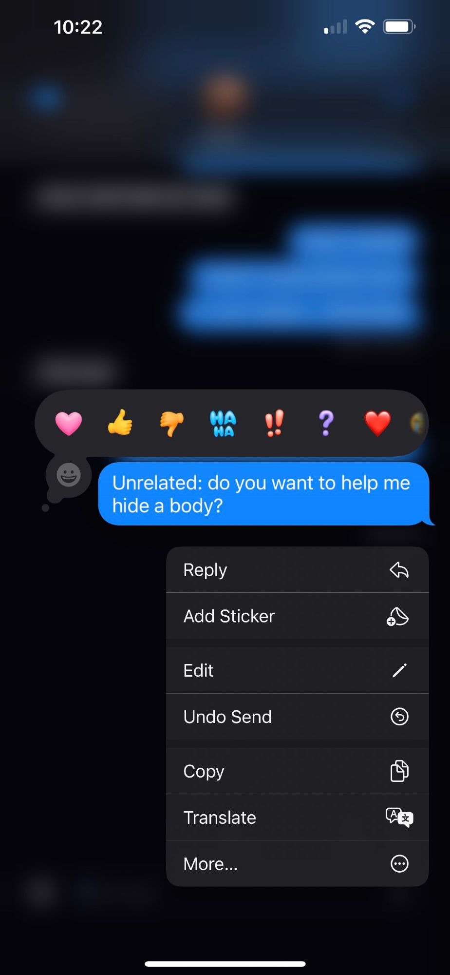 An iMessage that reads “Unrelated: do you want to help me hide a body?” The iOS 18 Tapback menu can be seen.