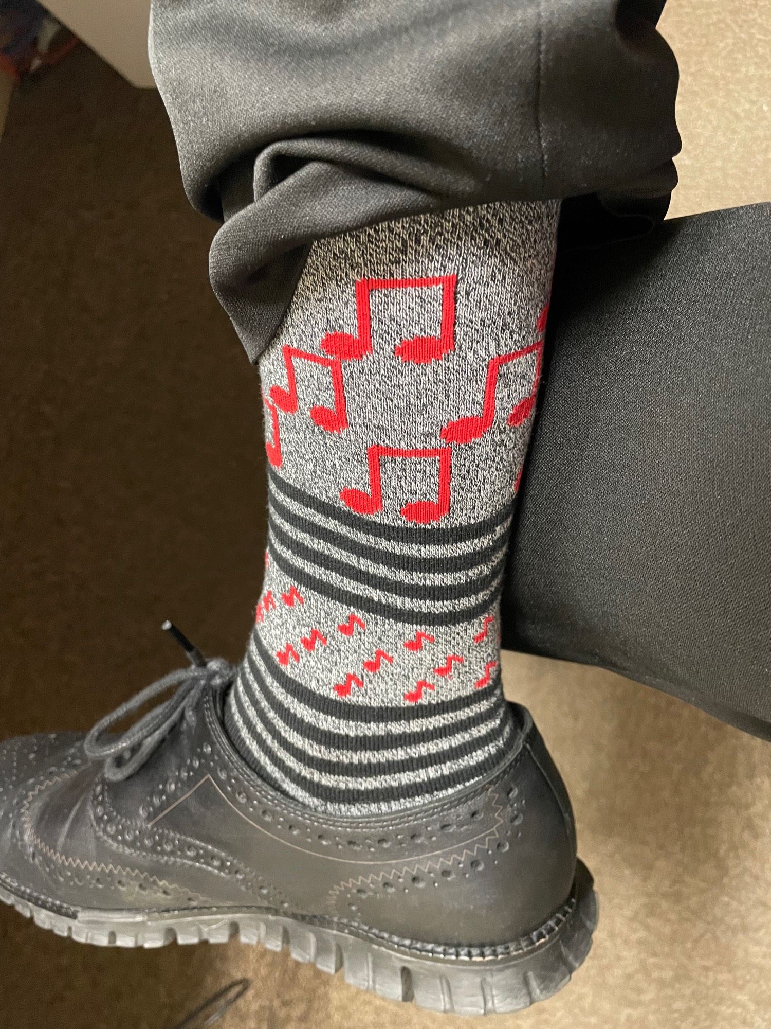 Gray socks with black stripes and red musical notes.