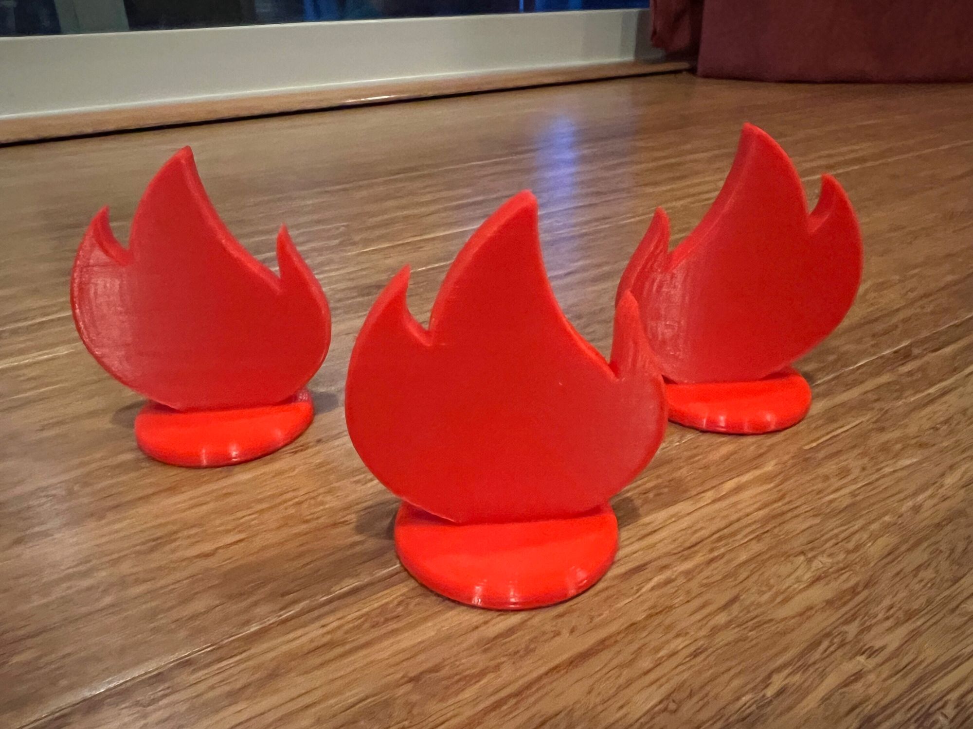 A photo of 3 printed flame game pieces.