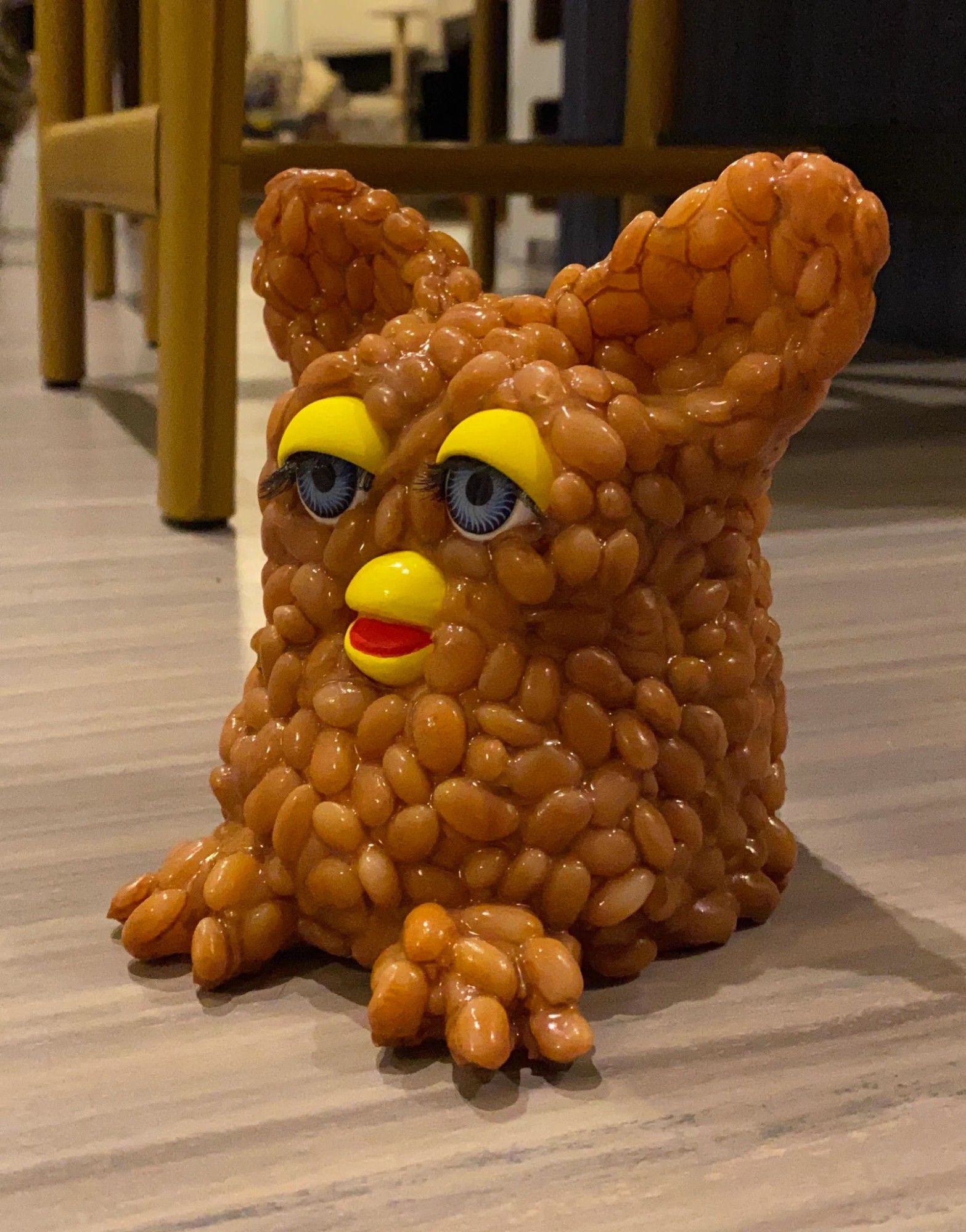 a furby that appears to be made out of baked beans