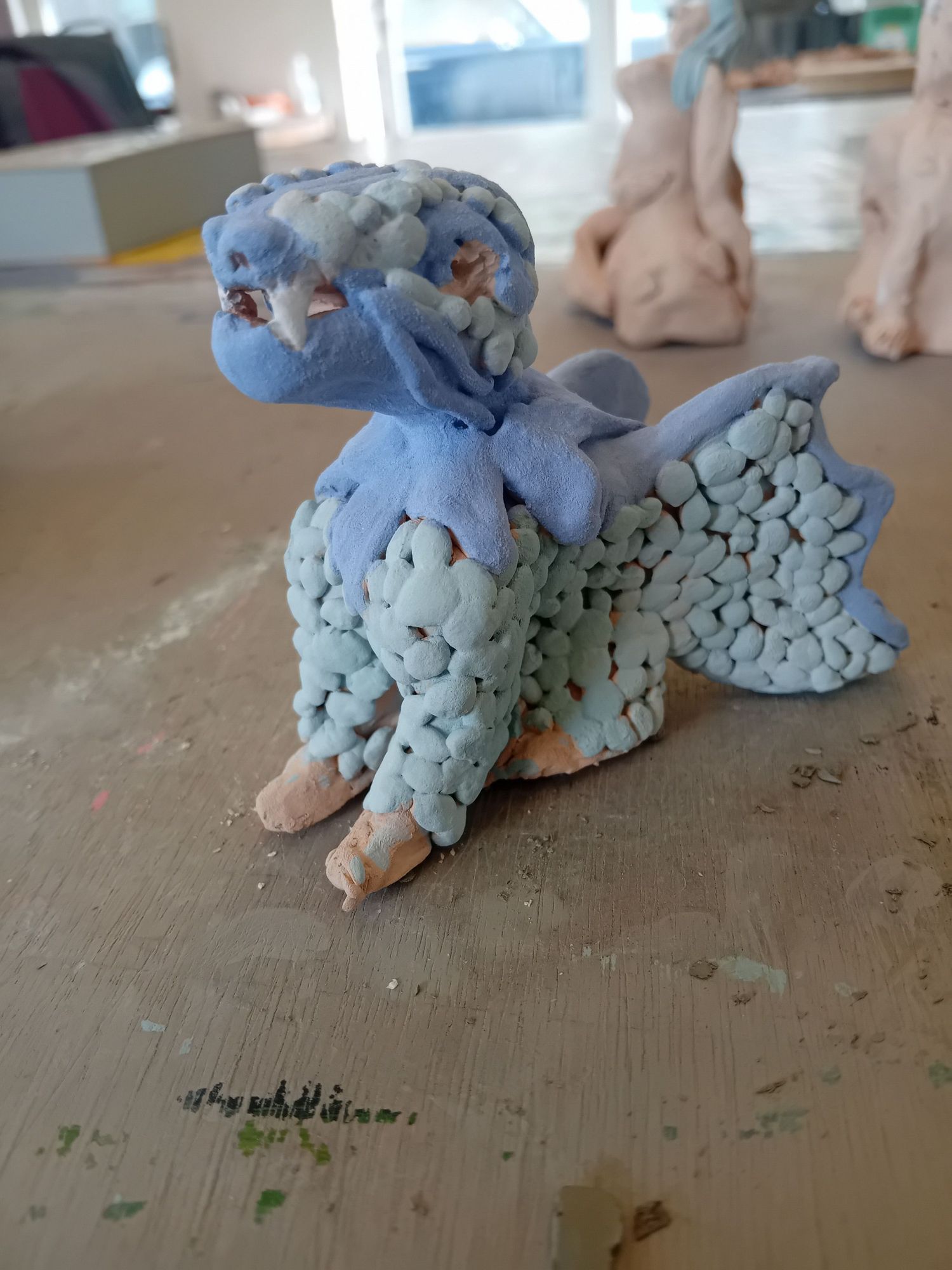 Small blue amd green sitting dragon, half glazed