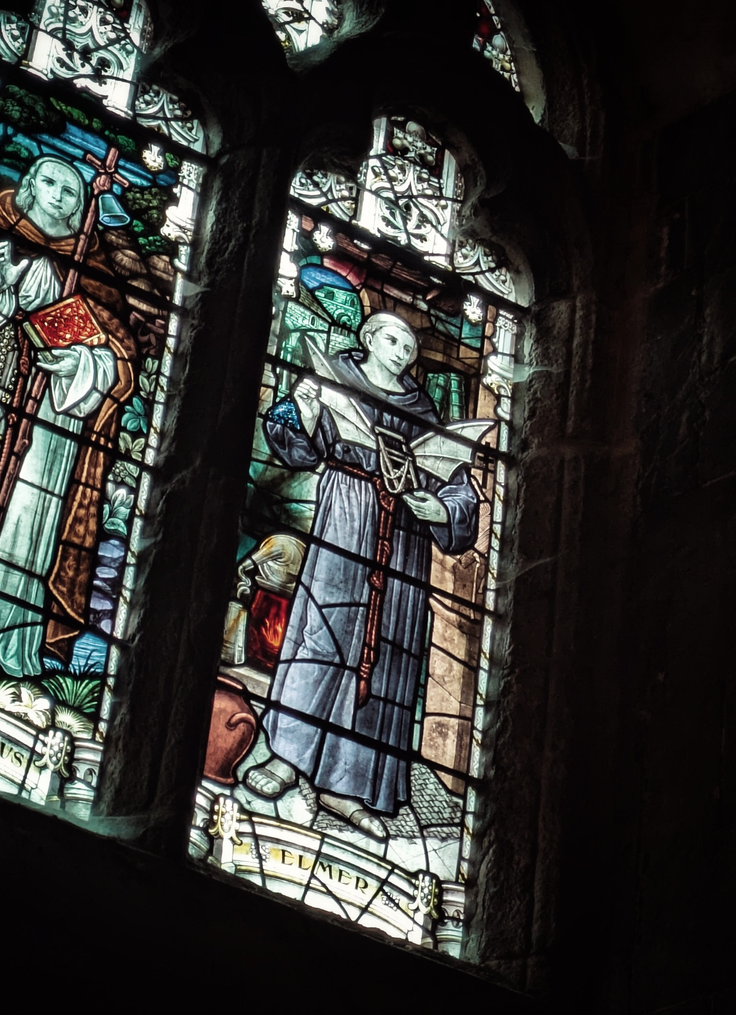 Stained glass window depicting Eilmer of Malmesbury holding a pair of wings.