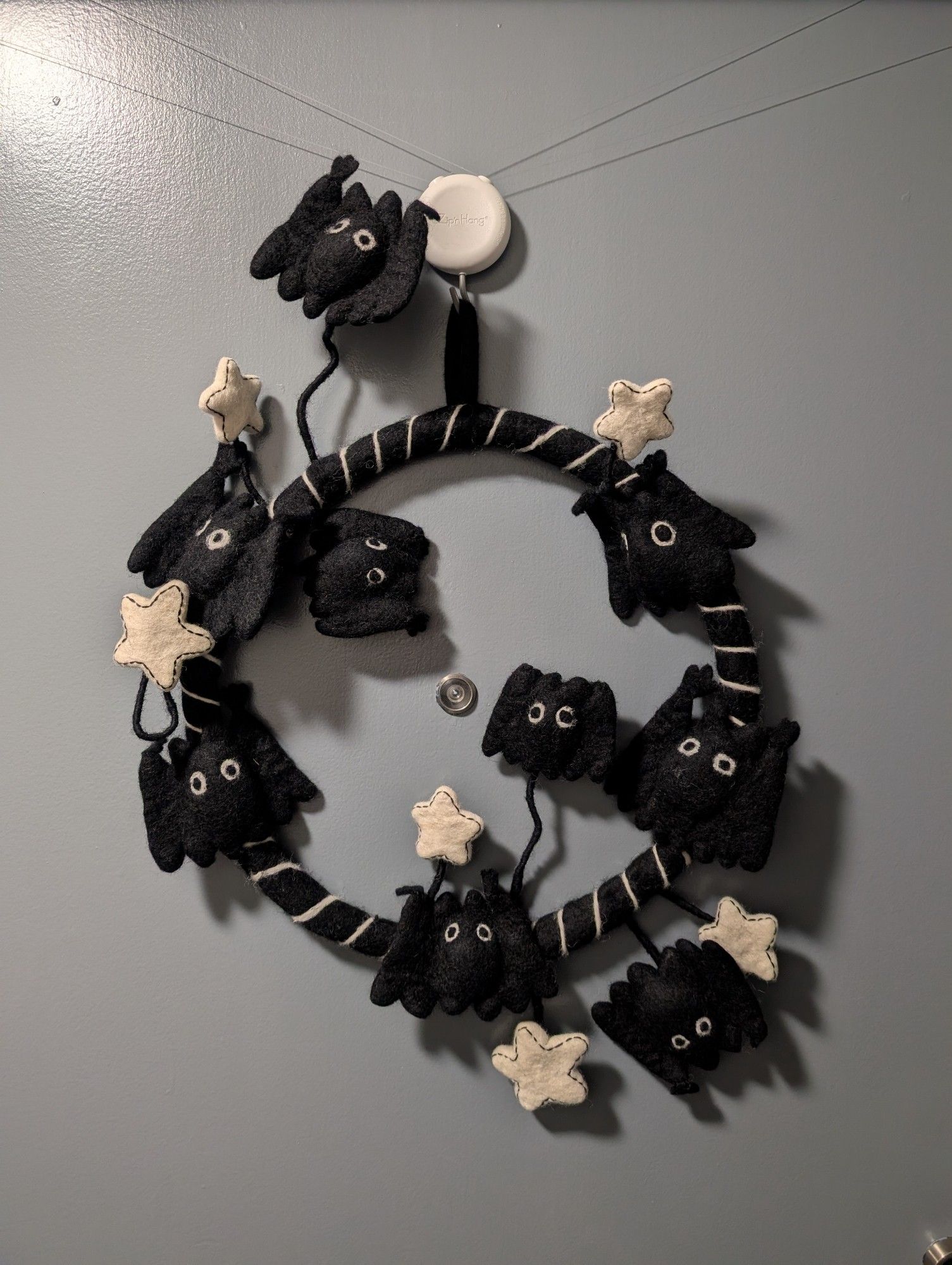 A black wool felt wreath with cartoony 3d bats and white stars