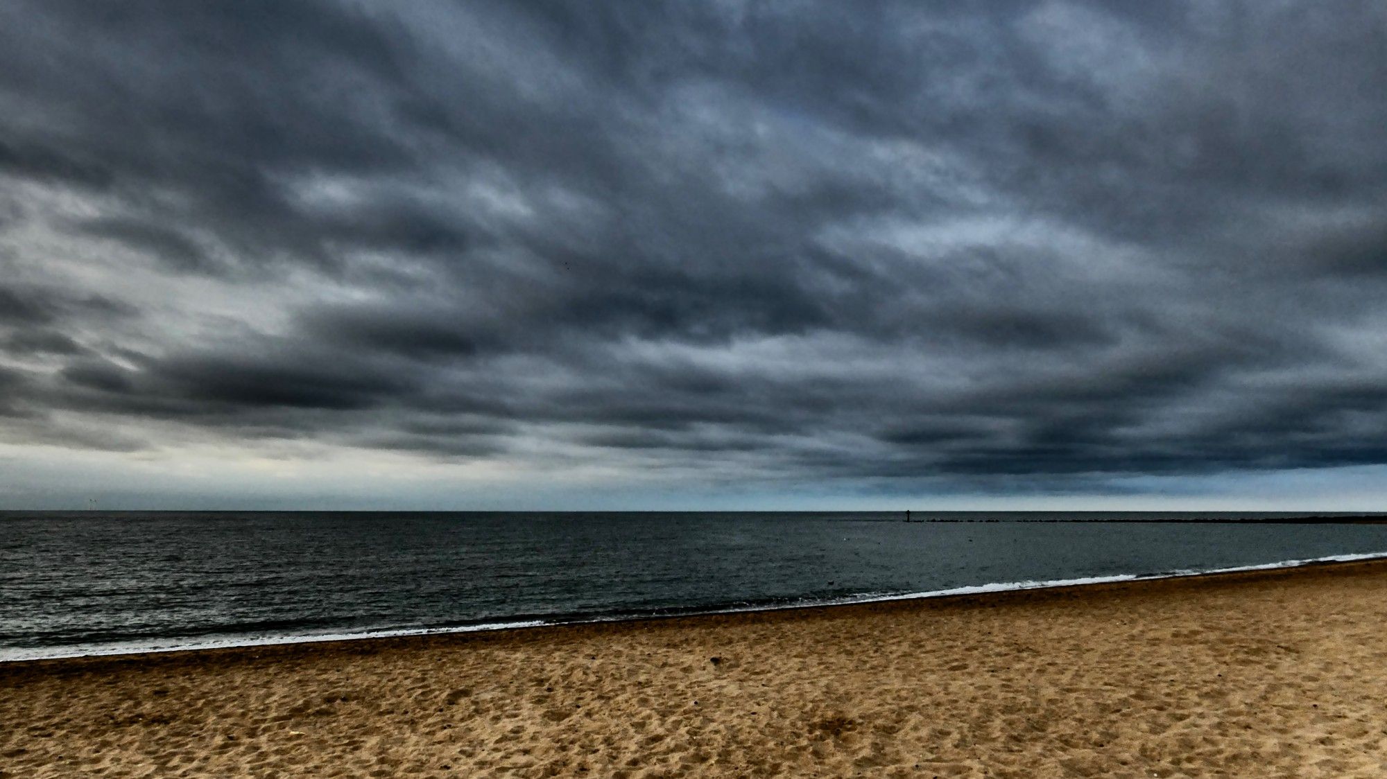 Seascape under a grey sky.