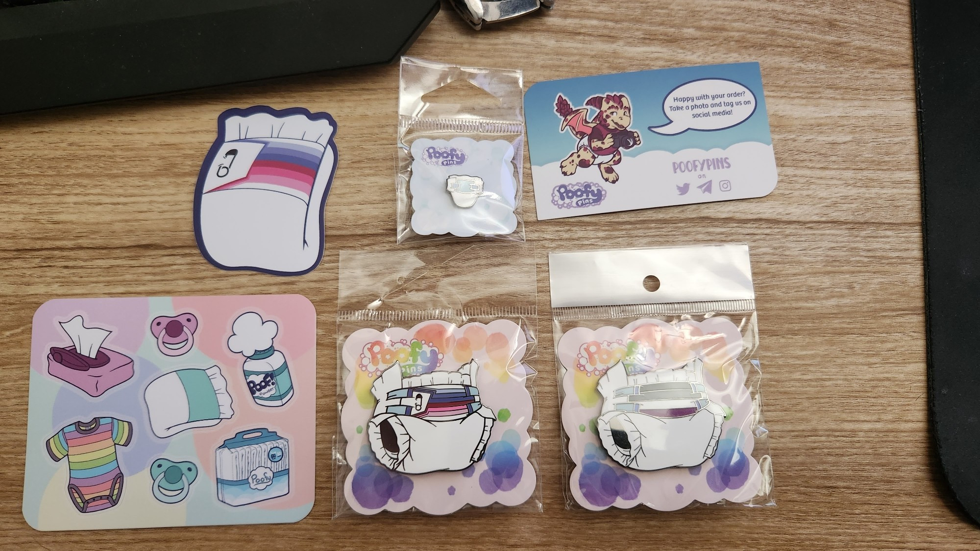 Asexual and AB/DL Pride pins from Poofy Pins, along with some of their stickers that came with. Kickstarter rewards, yay.