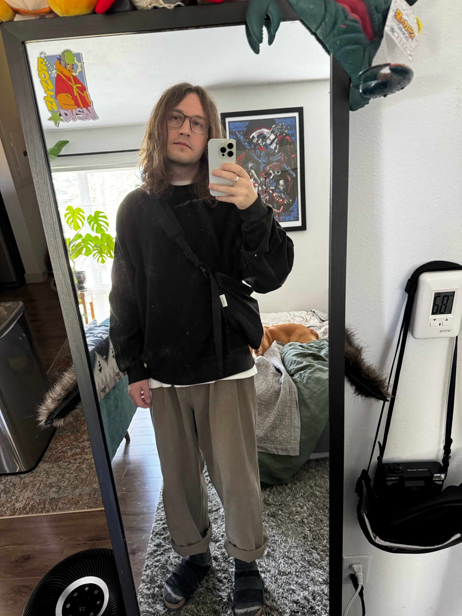 mirror selfy of a dweeb wearing baggy brown pants and black sweater and sandals and socks and long hairs